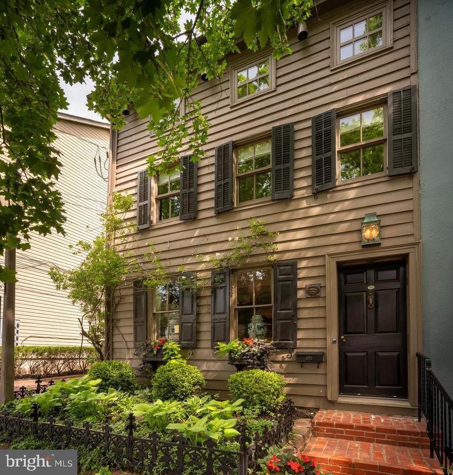 One of New Hope’s most exceptional properties, 70 W Bridge Street has been beautifully restored and features a separate guest cottage and studio, all centered around a truly enchanting hidden garden. A rare gem in the heart of town—complete with off-street parking.

This thoughtfully designed home showcases antique random-width oak and pine floors, exposed beams, vaulted ceilings, exquisite millwork, and three fireplaces. The chef’s kitchen is both elegant and functional, appointed with Carrara marble countertops, a marble island with a concealed TV, Sub-Zero refrigerator, Thermador six-burner dual-fuel range, two dishwashers, and custom cabinetry—perfect for entertaining.
The great room stuns with its cathedral ceiling, antique beams, gas fireplace, and oculus window, with French doors opening to a lush garden retreat. Outdoors, enjoy multiple seating areas throughout the formal yet flowing gardens, including a charming pergola for shaded relaxation and privacy.
Wander along stone and brick pathways to a delightful two story, one-bedroom guest cottage with its own kitchen and full bathroom and a stand alone private office/studio. Currently used as a single family residence, this property is zoned RB District, offering exciting mixed-use potential.
Ideally located just minutes from world-class performances at the Bucks County Playhouse, acclaimed dining and boutique shopping. As well as a short stroll across the river to more entertainment, dining and shopping in historic Lambertville NJ. This home offers not only luxury living, but an unmatched lifestyle in one of Bucks County’s most beloved destinations. Schedule your private showing today.