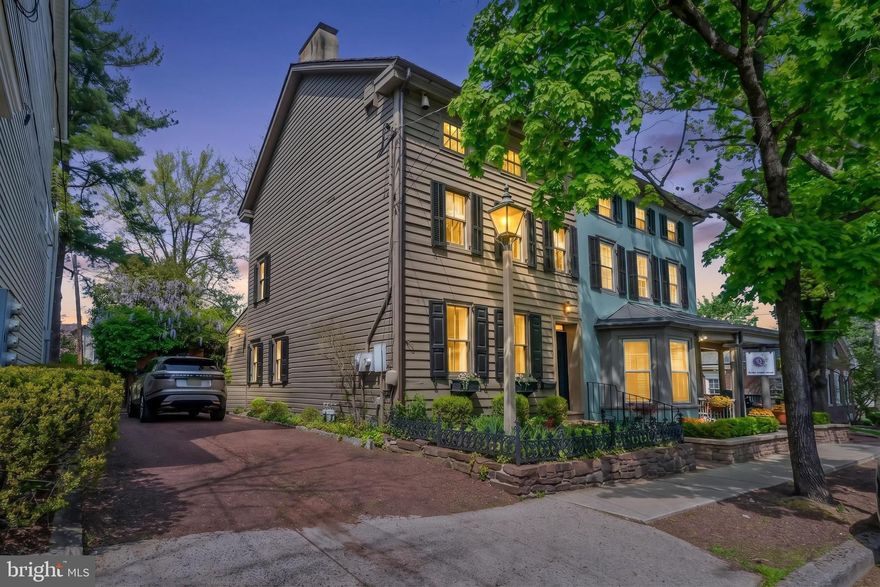 One of New Hope’s most exceptional properties, 70 W Bridge Street has been beautifully restored and features a separate guest cottage and studio, all centered around a truly enchanting hidden garden. A rare gem in the heart of town—complete with off-street parking.

This thoughtfully designed home showcases antique random-width oak and pine floors, exposed beams, vaulted ceilings, exquisite millwork, and three fireplaces. The chef’s kitchen is both elegant and functional, appointed with Carrara marble countertops, a marble island with a concealed TV, Sub-Zero refrigerator, Thermador six-burner dual-fuel range, two dishwashers, and custom cabinetry—perfect for entertaining.
The great room stuns with its cathedral ceiling, antique beams, gas fireplace, and oculus window, with French doors opening to a lush garden retreat. Outdoors, enjoy multiple seating areas throughout the formal yet flowing gardens, including a charming pergola for shaded relaxation and privacy.
Wander along stone and brick pathways to a delightful two story, one-bedroom guest cottage with its own kitchen and full bathroom and a stand alone private office/studio. Currently used as a single family residence, this property is zoned RB District, offering exciting mixed-use potential.
Ideally located just minutes from world-class performances at the Bucks County Playhouse, acclaimed dining and boutique shopping. As well as a short stroll across the river to more entertainment, dining and shopping in historic Lambertville NJ. This home offers not only luxury living, but an unmatched lifestyle in one of Bucks County’s most beloved destinations. Schedule your private showing today.