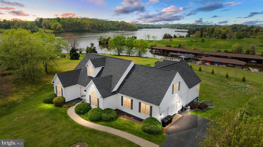 Nestled along the serene shores of Lake Anna, Virginia this exquisite waterfront retreat offers unparalleled tranquility and captivating views.  The possibilities are limitless at this turn-key waterfront, featuring 7 bedrooms and 4.5 baths.  With over 6,100 finished square feet spread over three levels, this exquisitely-maintained home offers ample space for entertaining, relaxing and enjoying stunning water views.  Completely furnished and offers high speed fiber internet.  This retreat operates as a successful short term rental and already has a rental history!  Whether you're looking for the perfect weekend escape, a relaxing primary residence, or a powerful investment property capable of generating incredible passive income, this property will meet everyone's needs.  With its charming architecture and meticulous landscaping, this home captivates from the moment you arrive.  Step inside to discover a spacious open layout featuring many upgrades.  The heart of the home lies in the expansive living areas, where panoramic windows frame stunning vistas of the lake.  The family room with vaulted ceilings, hardwood flooring,  gas fireplace with built in shelving is open to the breakfast room and spacious kitchen with a center island and stainless appliances.  Separate living room and dining room.  Main level primary bedroom has a custom walk-in closet, access to the deck and and en suite bath.  There are two additional main level bedrooms and a full bath.  Upstairs has two bedrooms, a sitting area and full bath.  Fully finished walkout basement with a family room, rec room, bar, two bedrooms and a full bath.  Outside, the allure of lakefront living awaits.  Step onto the spacious deck that was recently expanded to support the new hot tub where you'll soak in the serenity of the surroundings or descend to the boathouse for endless adventures on the water.  The boathouse has two boat slips each with an electric lift, a storage room and partially covered sun deck.  You also get your own private sandy beach here and all located in a No Wake Cove.  Don't miss your chance to make cherished memories at this extraordinary Lake Anna retreat.  This home also has a brand new 6 bedroom septic system that was just installed and rental history is in the documents section.