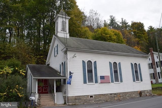 Originally a church in the quaint village of Axemann located across the street from world famous Logan Branch stream offering some of the best fishing in the state. Zoned Conservation, currently used as a 1 bedroom, 1 bath month-to-month rental featuring stain glass windows & 16' ceiling in great room, spacious kitchen with refrigerator, range, washer & dryer plus a separate dining room. Monthly rent is $700 tenants pays electric, natural gas, lawn care & snow removal. Natural gas forced air heat, there are 2 furnaces 1 in the basement & the other is located in back section of building. Visit Virtual Tour at https://rem.ax/2gWGRSf