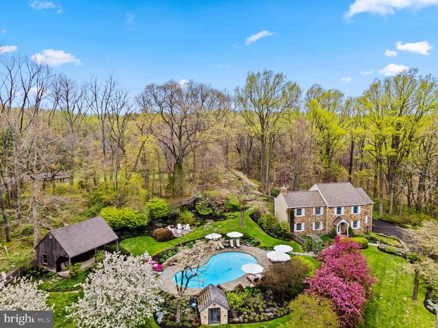A magical setting on one of Buckingham Township’s most coveted roads envelops this property, offering two homes on 4.27 hillside acres.  With manicured grounds, an inviting inground pool, stone pool shed, and mature perennial gardens, this unique property is simply enchanting.  A charming, totally restored vintage guest cottage with 1 Bedroom 1 Bath welcomes you at the foot of a serpentine hillside driveway.  At the crest of the driveway is the main residence, which at first glance appears to be a stone and stucco reproduction, but inside is a sleek, updated, “less is more” home showcasing a neutral palette throughout. It features bleached white oak wood flooring upstairs and down, modern lighting fixtures and ceiling fans, a flexible multi-tiered floor plan, and enjoyment of total privacy. The main residence is ideal for full time or part time living. Its generous living room is finished with built-in cabinetry and a gas fireplace, and leads to a separate dining room, with room for a proper dining table for entertaining, and rear glass enclosed vestibule with French door access to an outside secluded terrace.  Flanking the entrance hallway, with coat closet and powder room, is a wonderful home office with two walls of built-in bookcases.  Nearby is an open kitchen/breakfast room with terracotta flooring, granite counters, and stainless-steel appliances including Dacor double wall ovens, a Bosch dishwasher, GE electric cooktop, and Subzero refrigerator/freezer with ice maker. Open to the kitchen is a newer addition, a sprawling great room with a wood fireplace near one end, vaulted ceiling, architectural lighting fixtures, and space that allows for whatever use or furniture configuration might suit your needs.  Upstairs above the original footprint of the home, the main bedroom suite is sunny and spacious, with two ample closets,   and a large dressing room with built-in ironing board, ready for a great walk-in closet, additional home office, or even a nursery, if desired.  The main bath offers a jetted tub and shower.  Two spare bedrooms are nicely finished, with ample closets, one closet leading to the floored attic above.  A hallway bath is finished with white tile flooring, a corner jetted tub and stall shower.  The lower level has a finished family or media room with wall-to-wall carpeting, sauna, laundry, and access to the two-car attached garage.  There is also a large, newer daylight gym/exercise room that is beneath the newer great room, with the potential to join the two spaces with a staircase, creating a two-level space.  Outdoor spaces include a private terrace for dining, sunken fire-pit patio, and the bluestone bordered pool area which is an oasis in and of itself, privately situated and nestled away from the house.  The restored guest cottage, on the lower tier of the property, has been beautifully renovated and is totally self-contained.  Upon entering through its original Dutch door, the cottage is finished with white plaster and exposed stone walls, wide plank and old brick flooring, and deep sill windows.  The dine-in kitchen is outfitted with a stainless stove, dishwasher, refrigerator, microwave, deep Franke sink and natural stone counters.  The kitchen flows to a gathering room with stone fireplace (non-working) and sunny deep sill windows.  On the upper level, the bedroom features a vaulted ceiling with exposed wood beams, built-in bookcases, and exposed stone walls. Down a short hallway is the renovated bath, which included new cabinetry with stone counters, flooring, newly exposed stone walls, and a washer and dryer (2016). The cottage is cozy and beautifully finished with  total attention to detail- great for guests, grown children, or even as a home office.   This is a property with something for everyone- from the transitional, cool vibe in the main house, to the quintessential old-world charm in the cottage.  A captivating and convenient location offering  beauty in every season!