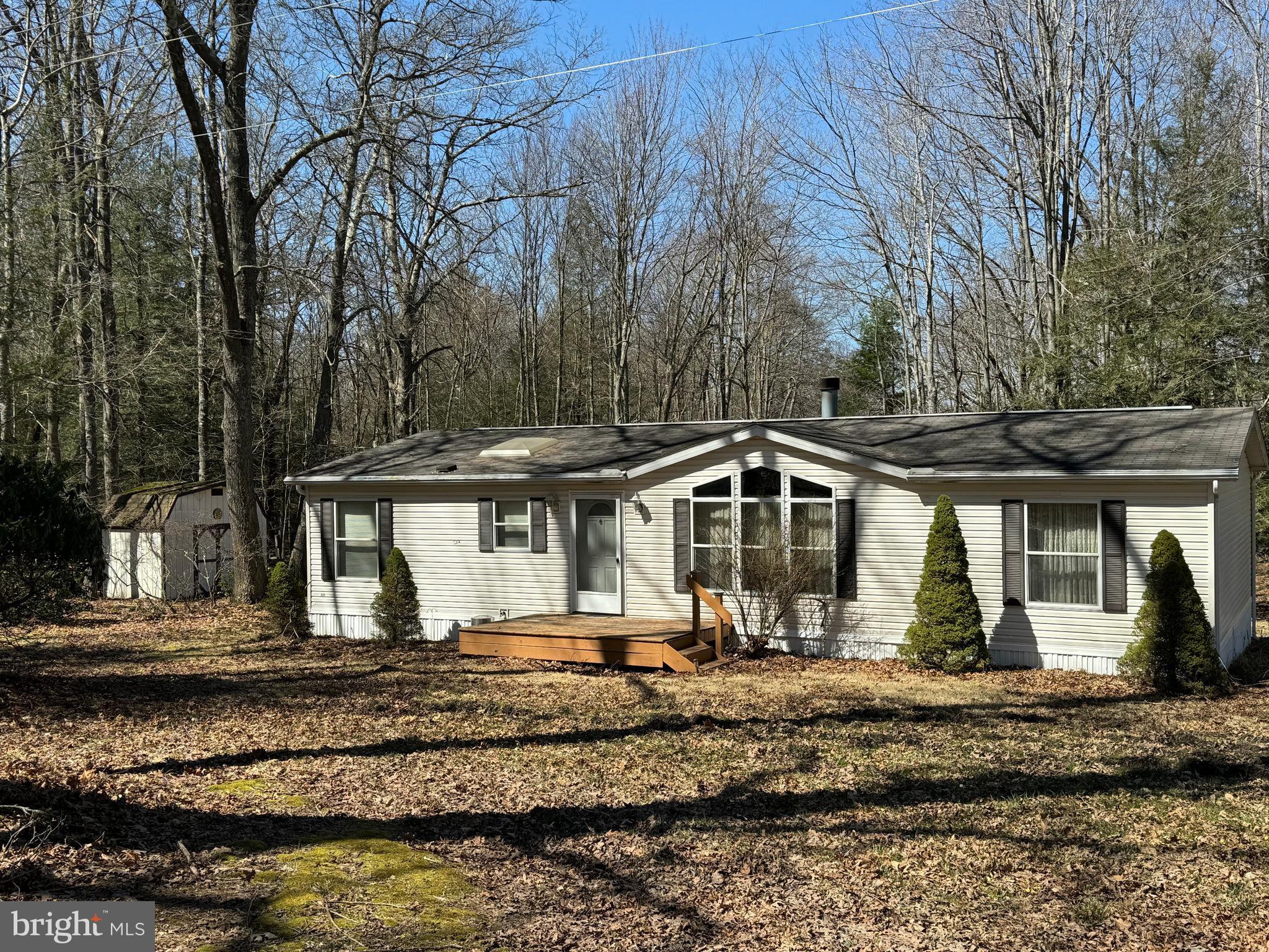 Take a look at this 1999 double wide in very good condition sitting on a larger, almost 2 acre lot. The home features 3 bedrooms and 2 baths with one bedroom and one bath being primary. Primary bath features shower unit and soaking tub. Home has vaulted ceilings and the living room has a huge built in bookshelf surrounding a stone fireplace. Kitchen is light and airy with a mud room off of the kitchen with washer and dryer. Front stoop and huge rear deck. Whole home and roof has been pressure washed and looks great. Very close to Deep Creek Lake, Wisp Ski area, and ASCI.