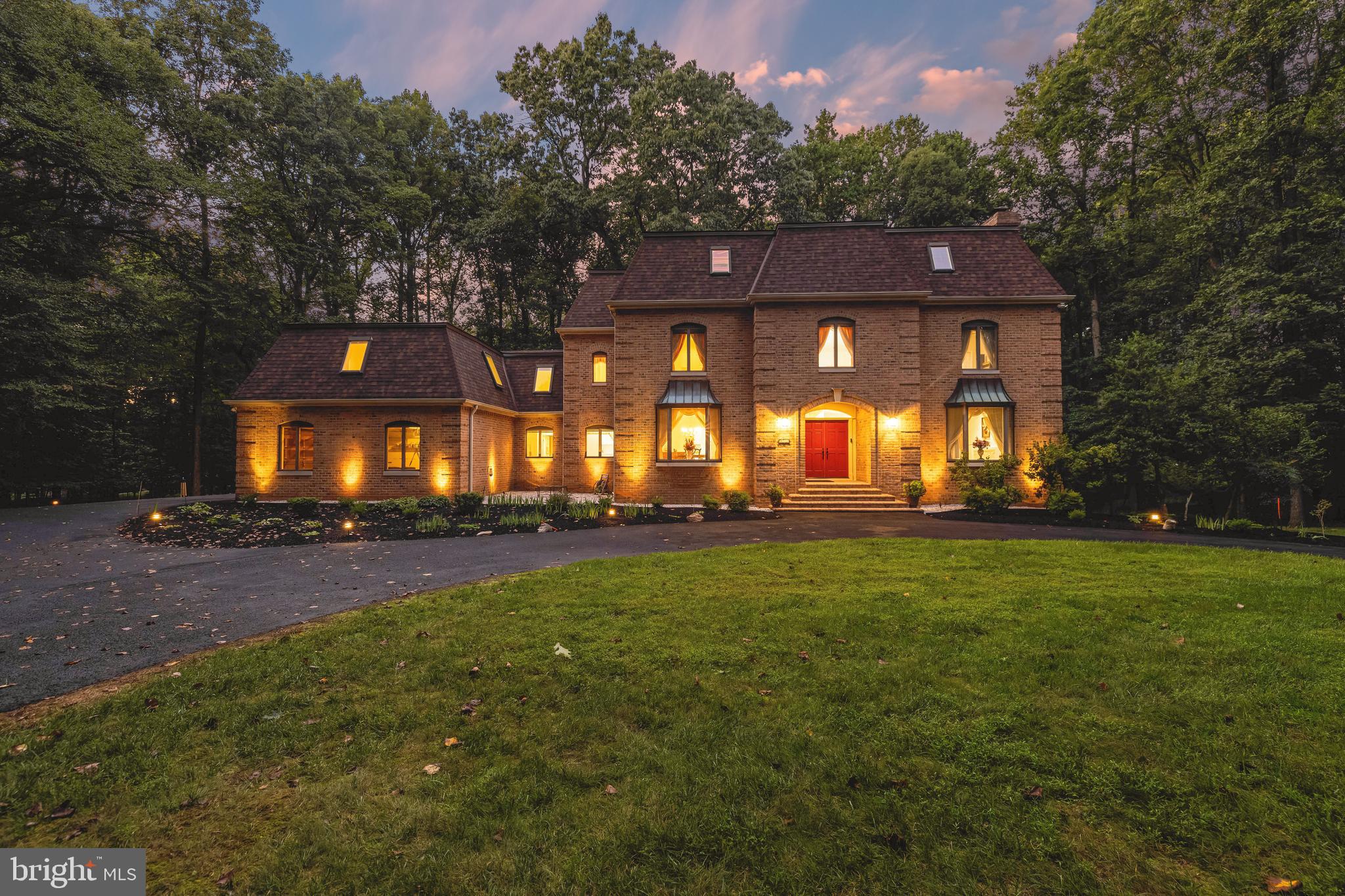 This expansive all-brick manse boasts a delightful approach around a specimen tree-lined circular driveway to drop you off at the stately front porch with bullnose brick steps and double door entry. An impressive 2-story marble foyer greets you with a sweeping staircase and crystal chandelier then opens to substantially sized living and dining rooms with gorgeous oak hardwood floors. The recently reimagined eat-in kitchen features quartz countertops, cedar-lined walk-in cedar pantry and stainless steel appliances with a cozy adjoining breakfast room. Take your evening respite in the family room in front of the stone fireplace with your favorite drink mixed at the wet bar. Perhaps you'll relax on the composite deck each evening listening to the crickets chirping in the peaceful woods beyond. Walking up the dramatic staircase, the upper level hallway connects with the capacious primary suite, replete with dressing area and a luxurious renovated marble bath with soaking tub, marble shower and separate vanities plus two additional spacious bedrooms and convenient upper level laundry. The westerly wing of the home offers two additional bedrooms, baths and living areas to accommodate your fluctuating household needs while the fully finished lower level boasts versatile spaces for entertaining, exercising or for all of your hobbies and interests. Whether on the deck, patio or picnic terrace under the shade of gorgeous Japanese snowball trees, this property provides a peaceful, tranquil experience.