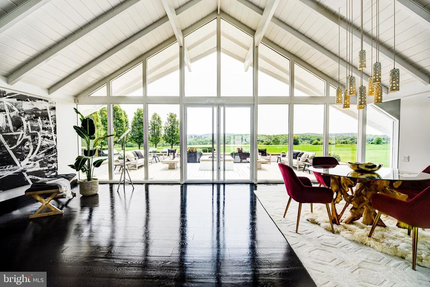 Please note that the above-referenced price reflects the Reserve Price for the property, which is being marketed for sale by luxury private auction. Bidding is open now through January 25. Seller reserves the right to accept or reject bids. 5% Buyer’s Premium. Additional terms apply.  Please visit Paramount Realty USA’s website for more details.

Surrounded by lush greenery on an expansive 1.4-acre lot, this manor captivates all with its incredible views, remote privacy, and impeccable details throughout. Located in New Hope , PA less than 10 minutes from Main Street, Bucks County water- front and Playhouse.  This beautiful  three bedroom, four bath custom-built contemporary-style residence truly exceeds all expectations.

As you drive up the extensive driveway, you are welcomed to the property by an extravagant front yard with manicured hedges and vibrant foliage in your front gardens. The interior has  white- oak hardwood floors w/ glossy black finish & has been  complemented with recently added multi-color accents that showcase the versatility of the black and white theme. Under a vaulted ceiling with a wall of glass and those alluring vistas, the original heart of the home has an open floor plan with zones denoted by seating places, a fireplace, lighting, and a wet bar accented with bespoke cabinets. The family room is adorned with an abundance of natural light, intimate seating, a fireplace, built-in bookshelves, and an office space W/ custom-made  desks .The kitchen is  equipped with a 16-foot island, custom wooden cabinetry, 2 Bosch dishwashers, 2 Sub-Zero refrigerators / freezers, a polished stainless steel ventilation hood, and sparkling Quartz countertops finished with beautiful waterfall edges. All of the rooms enjoy access to a rear patio, keeping with one of the critical tenets of mid-century modernism. Nestled in the rear of the home are two private guest rooms with en suite bathrooms, walk-in closets, and ample closet space. Both of the private guest suite's bathrooms are masterfully constructed of quartz and marble.

The primary suite boasts elegant touches and remote privacy, with beautiful countryside views. The  double vanity has added amenities built in, a large walk-in shower is completed in book-matched quartz slabs. The master bedroom has direct access to the private backyard terrace and benefits from the valued panorama. Here and in each bedroom, power draperies provide complete shade and solitude. 

The backyard truly encompasses the feeling of your own private resort hosting a refreshing 60Kgallon heated pool, a custom wooden deck with a swanky outdoor kitchen  bar, a built-in bonfire, yards of rolling green grass, and exquisite views of the mature verdure in the distance.  A whole-house generator that will carry electricity for weeks, a 2+ plus car garage with extra storage a refrigerator & temperature controlled heating & cooling. The luxury laundry room also has a refrigerator, whole-house audio that extends outside to the front & back of the house is perfect for entertaining guest. Custom storage throughout, custom lighting, 9 skylights, water features along the front facade, and a location with traditional Bucks County views are a few of the many impressive characteristics the property embodies.  

This Jules Gregory-designed mid-century modern property stands out in New Hope for its uniqueness, lineage, and craftsmanship. The brick and glass, which bears more than a passing similarity to the Swiss Miss A-frame homes of Palm Springs, is a groundbreaking design for our region, dynamic and dramatic, sophisticated and peaceful. The home has previously undergone a careful expansion and 360-degree renovation overseen by professional designers who worked their magic to transform it into a luxurious chalet-style house that embodies their philosophy of clean, crisp, comfortable modernity. It is wrapped in glass and overlooks hundreds of acres of preserved Buckingham Township farmland.