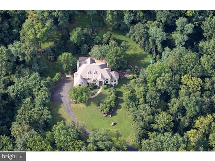 This is a quintessential property for privacy, low maintenance, gracious living & entertaining. Preeminent builder, Zaveta, created stunning  estate home w/attention to detail. Vaulted ceilings, dramatic windows, beautiful millwork, stunning outdoor patio w/cascading waterfall, pond, soaring pines. Woods line driveway to this oasis close to Bucks County amenities. Step into 18' high entry & be captivated by architecture that creates a distinctive ambiance, incl 2nd fl hall bridge w/2-sided views. Turret shaped, windowed sunroom; huge, open kitchen/family room w/ floor-to-ceiling stone fireplace & custom cherry cabinetry & wall of built-ins. 2-tier granite eating island w/wine rack & storage, wood flrs, 5 lighted art niches . 4 bedrooms have 12' vaulted ceilings; master suite has gas fireplace built into floor-to-ceiling wall of cherry cabinetry. French doors to sitting rm & balcony. Bath w/marble floor & shower, jetted tub, walk-in closet, 2 sink vanities. Sketch plan for finished basement available.