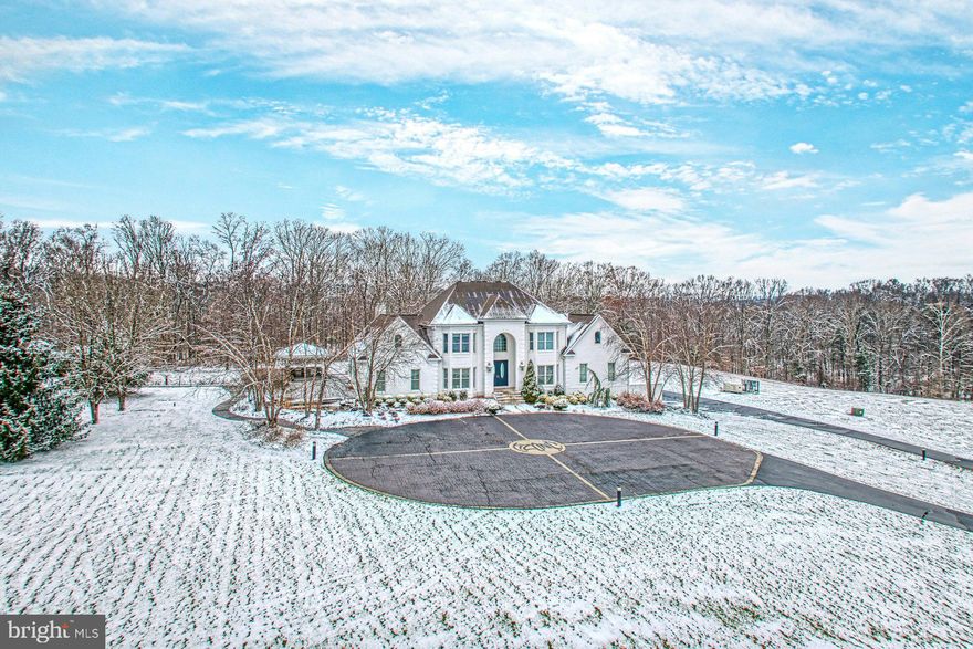 BEST AND FINAL OFFERS DUE BY TUESDAY 12/09 AT 5:00PM

Introducing a private 17.94-acre estate in Leesburg where modern design, sweeping interiors, and serene outdoor living come together to create a rare retreat. A grand white-brick façade sets an elegant tone from the moment you arrive, while inside, expansive open spaces unfold across more than 7,000 square feet of refined living.

The main level has been thoughtfully reimagined for both luxury and livability. Walls were removed to create a seamless flow drenched in natural light, enhanced by large-format marble flooring with dramatic veining and “high-resolution white” walls that serve as a gallery-like backdrop for art and statement furnishings. The gourmet kitchen blends marble countertops with custom glossy cabinetry, creating a sleek, architectural focal point perfect for culinary pursuits and effortless entertaining.

A highlight of the home is the sophisticated main-level primary suite. This private sanctuary features a spacious bedroom with views of the grounds, a spa-inspired bath, generous dressing areas, and the convenience of an in-suite laundry—designed for comfort, privacy, and ease of daily living.

The lower level elevates the home’s entertainment potential with a state-of-the-art theater, full bar, wine cellar, and expansive recreation spaces ideal for gatherings both large and intimate. Additional indulgences include a dedicated wellness room with space for restorative treatments, a sauna, and private access to the outdoor spa.

Outside, the estate’s acreage creates a sense of true escape. A resort-style pool, outdoor kitchen, and terrace are surrounded by wooded privacy, offering endless opportunity for recreation, relaxation, and hosting. With picturesque trails and rolling landscape, the grounds feel like a secluded destination all their own.

Balancing architectural sophistication with a deep sense of calm, this extraordinary property was designed as a modern retreat—where open, airy living spaces, luxurious amenities, and acres of natural beauty come together in perfect harmony.