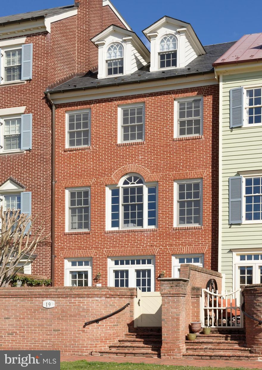 Glorious river views looking South are enjoyed from every level of this handsome brick home in Harborside where finish detail is extensive and custom-milled built-ins are numerous.  For the selective buyer seeking truly distinctive living quarters on the Potomac River in Old Town, this unique floor plan offers gracious open living and dining rooms for entertaining, a sunny kitchen with adjoining family room, all with breathtaking water views.  5 fireplaces, beautiful hardwood floors and deep custom moldings add touches of character, plus an Otis interior elevator will transport you to all floors.  This spacious home features 3/4 bedrooms, 3 full and 2 half baths, a library with fireplace and custom bookshelves,  a generous master suite with sweeping river views plus fireplace and amazing closet space.  Two enormous guest rooms are found on the top floor with a guest bath featuring a skylight.  The private brick walled terrace with French doors from the living room offers quiet outdoor space with lovely plantings.  And the southernmost terrace with tall curved brick walls overlooks the beautiful park beyond with glistening water views to the south.   2-car deeded parking conveys.  Please enter from the southern side, along the riverfront brick sidewalk to #19 gate.  Take a 3D Tour of 19 Wilkes : https://tours.linenandlens.com/1580675?idx=1