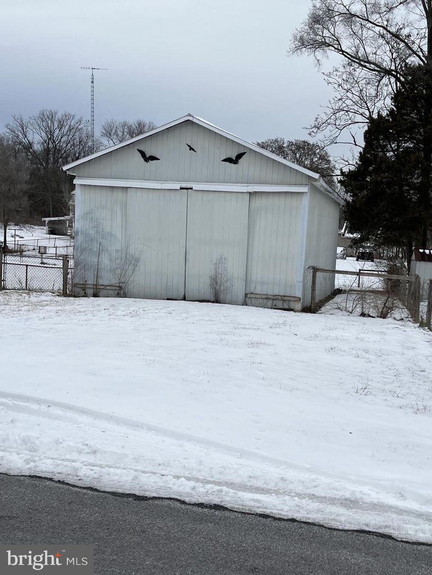 This is an in town lot, improved with a metal building. Gravel floor and electricity.
Dimensions are 20 feet wide, 52 feet long,  13.5 feet high.

It is NOT zoned commercial. Ideal for storage-boats, campers, etc.