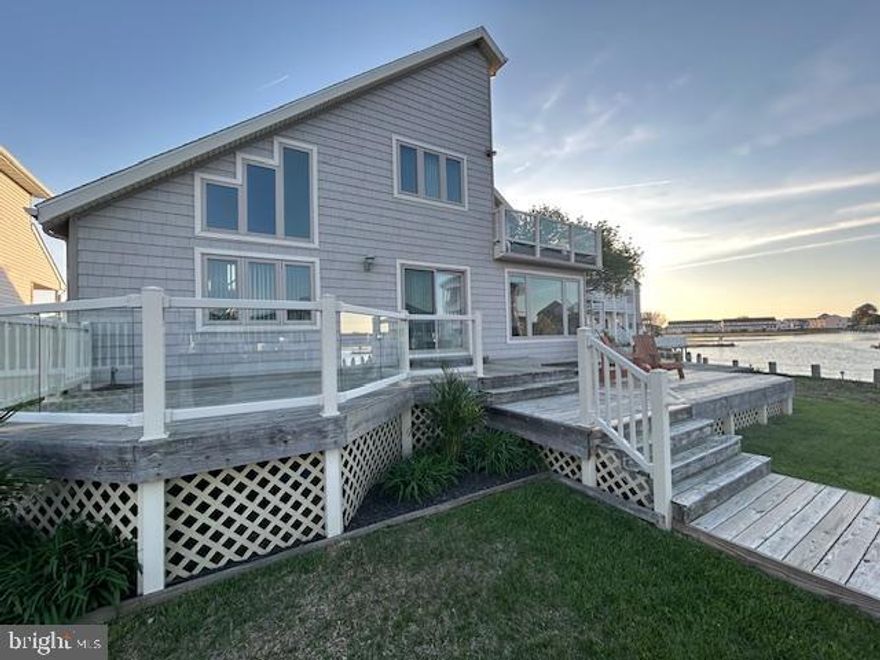 TERRIFIC WATERFRONT LOCATION! BEAUTIFUL WATER VIEWS!  This lovely 3 BR 2 BA home is located at the end of a large basin that leads out to what the locals call "The Fenwick Ditch" and out to the open bay! The large waterfront 2 level back deck offers open bay views and lots of area for the entire family to enjoy being outside on the water. The boat dock and lift are right out your back door! You see the water as soon as you walk in the front door and enter the large living area with vaulted ceilings. The kitchen has been totally redone with granite counter tops, stainless appliances and custom cabinets and yes you look out at the water from both the kitchen and dining area. There is also a sun porch off of the dining area where you can relax and enjoy the views all year long! There is a convenient bedroom and bath on the 1st floor. Upstairs are 2 additional bedrooms both with lots of windows and a large deck with fabulous views overlooking the water. Interior features include ceiling fans, ceramic tile, energy efficient windows, recessed lighting, crown molding, and an attic with pull downstairs.  The 2-car garage features two separate doors, both with remote access, and a high ceiling that provides lots of storage and a 2nd attic with pull downstairs. This home is at the end of a quiet cul-de-sac that overlooks the bay where you can watch the beautiful Ocean City sunset! Located in the popular residential area of Caine Woods in North Ocean City where you are close to restaurants with easy access by boat! This unique property is for those that are looking to really enjoy open water views and direct access to the bay!