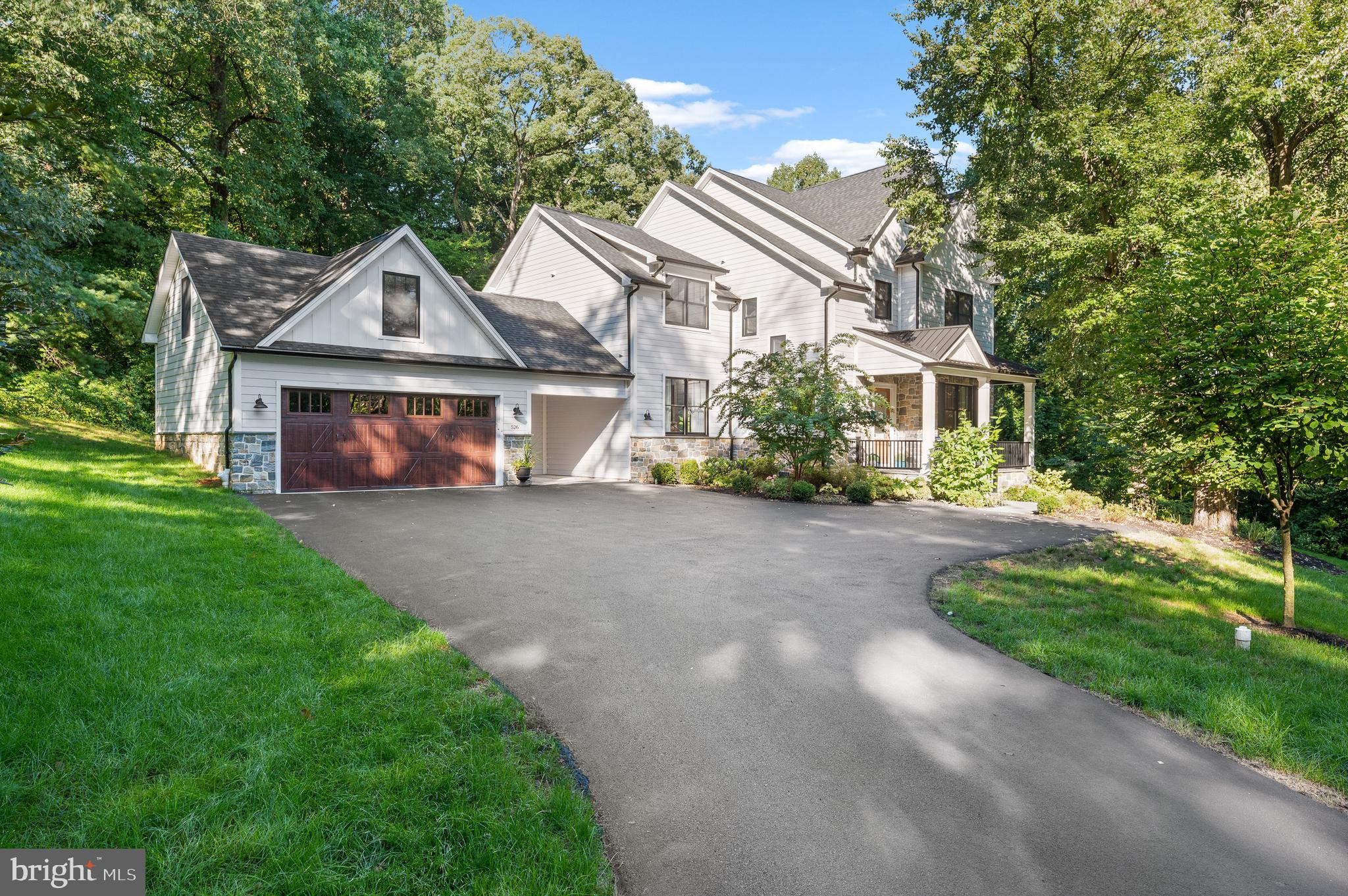 Town and Country living in Saint Davids. Better than new construction in a premier location on Philadelphia's Main Line. This home offers privacy, along with unbeatable convenience. Mature trees surround this super chic new home. You pull down a private lane off of King of Prussia road, and you are immediately wowed by the serene, quiet setting. Exterior is stone and siding, with a Flagstone front porch. 2 car garage and one car open carport lead you into a mudroom with brand new powder room and built in cubbies and storage and shiplap walls. The interior millwork is very updated and fresh, this home is not what you will expect. Open concept floor plan focuses on the kitchen with a 10 foot island. Top of the line appliances and quartz countertops. Custom Century Cabinets, Thermador appliances, including wine refrigerator. Walk in pantry, custom trim throughout, Coffered ceilings, modern staircase with windows, Beams in the family room, multiple barn doors, custom transoms and many more fabulous details. There are 4 bedrooms on the main level and 3 full baths along with 2 finished lofts with full bathrooms, that could be used for bedrooms, home offices or family rooms. Main bedroom suite has a covered porch connected, that makes it feel like a retreat. This home is one you need to see to experience! Located minutes from the Radnor train station, convenient to the city, this location is a real winner! Walking trail next door to the cul de sac street also called Montgomery Lane, for social gatherings or walking into Wayne. Very close to Radnor train station and Radnor Elementary school! Home also has EV charger for electric cars and SUV's.