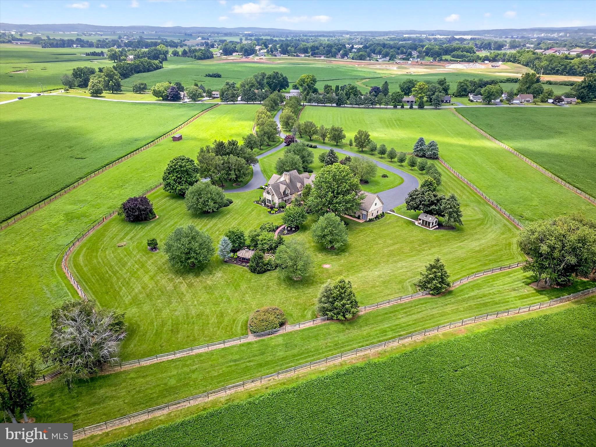 Welcome to this meticulously preserved equestrian estate, set on 23.13 stunning acres in scenic Annville, Pennsylvania. Designed with equestrian amenities and peaceful country living in mind, this gated and fully fenced property offers exceptional privacy and tranquil setting. A long, tree lined driveway winds through beautifully landscaped grounds, leading to an elegant main residence and thoughtfully planned equestrian facilities, blending lifestyle, comfort, and functionality in one remarkable offering. Inside, the main home offers six bedrooms, seven full bathrooms, and two powder rooms. The main level welcomes you with hardwood floors in the living room, complete with a gas fireplace, perfect for cozy evenings at home. The formal dining room provides an ideal space for hosting special occasions, while additional gathering areas throughout the main level offer flexibility and charm. Just steps away, the family room features stone tile flooring, built-in shelving, and a second gas fireplace, creating a warm and relaxed atmosphere for everyday living. The gourmet kitchen is designed to impress, featuring granite countertops, a center island, top-of-the-line stainless steel appliances, and a bright breakfast nook. Whether preparing a quiet meal or entertaining a crowd, this kitchen is perfectly suited for both. A main level bedroom with an ensuite bath offers comfort and privacy for guests, while a second staircase provides access to both the upper and lower levels. Upstairs, the expansive primary suite is a true retreat. Vaulted ceilings, a private balcony, and a generous walk-in closet create an elegant and peaceful space. The suite includes two stylish bathrooms, one with a stall shower and the other with a stall shower and soaking tub, making it the perfect place to relax and unwind at the end of the day. Four additional bedrooms and three full bathrooms provide ample accommodations for guests, including one bedroom with a versatile bonus room currently used as a music space. The fully finished lower level continues to impress, offering a spacious recreation area perfect for entertaining, a custom bar with seating and a beverage cooler, and an exercise room with a full bathroom. A private sauna room with seating provides the ultimate in wellness and comfort right at home. Outdoor living is equally inviting, with a stone patio accessed directly from both the kitchen and family room. A covered dining area and firepit offer year-round enjoyment, while a nearby path leads to a charming footbridge over a tranquil pond and a peaceful screened gazebo, perfect for quiet moments surrounded by nature. For equestrian enthusiasts, the property is truly a dream come true. A separate gated entrance leads to a private, well equipped equestrian center, complete with a nine-stall barn with a washroom, an outdoor riding arena, fenced paddocks, two run-in sheds equipped with automatic waterers, and a second barn with additional storage and a private flex space with a half bath. A tenant house offers additional living space and functional flexibility, with two bedrooms, one full bathroom, and a laundry area. This extraordinary estate offers a rare combination of timeless beauty, exceptional amenities, and equestrian functionality. With expansive indoor and outdoor spaces, panoramic views, and a setting designed for year round enjoyment, it’s a place where both people and horses can thrive in comfort and style. Schedule your private tour today to experience this one of a kind property.