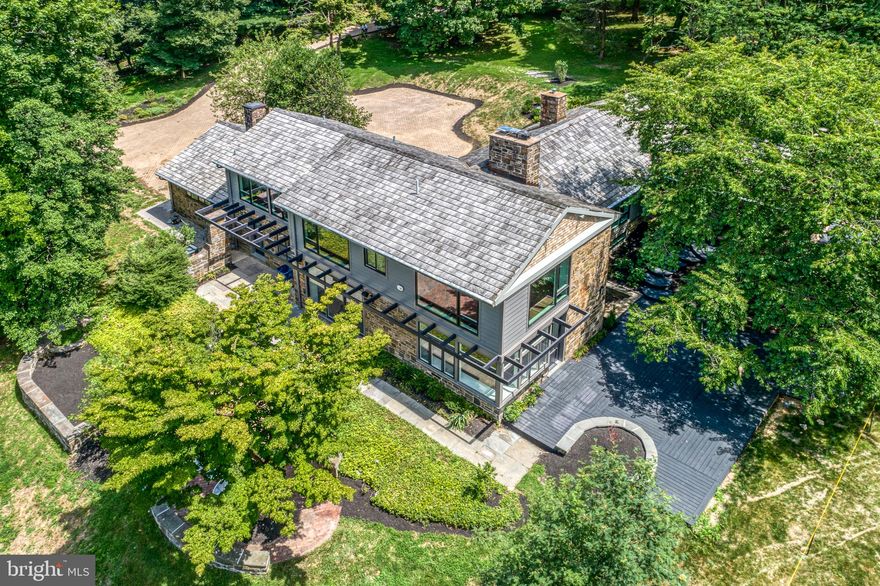 This spectacular and fully renovated contemporary on 2.25 acres with a gated entry will have you wanting to be in two places at once- the well-appointed interior and the incredible dream-like park setting.  The setting feels bucolic, is steps from the best of Wissahickon Valley Park in the heart of Northwest Philadelphia.  With 4000 square feet of living space this home boasts 5 bedrooms, 5.5 bathrooms, 3 fireplaces, 3 separate zones for heating and air, and floor to ceiling windows. On the main floor, the kitchen boasts an oversized 9'x4' island with seating, Quartz countertops, carrera marble backsplash, abundant pantry storage, and a GE Cafe appliance suite including a 6-burner range, hood vent and a wine refrigerator. The adjoining dining area and open living area beam with light and overlook the lush yard with green as far as the eye can see.  Sliding glass doors to a brick patio overlooking the lush green landscape await you.  Step up to a second living space and a main level bedroom or home office which feature gorgeous, wood vaulted ceilings, custom trimwork, a fireplace and floor-to-ceiling windows.  This floor is complete with another full bathroom with a jacuzzi tub and a home sauna!  This floor has direct access to the covered outdoor patio with vaulted ceilings and wood burning fireplace.  The upper level features 3 en suites all with large windows and walk-in closets with breathtaking tree top views.  There is an ideally situated laundry room with a sink, extra cabinetry and quartz counters.  The true master suite  features a sitting area, two walk-in closets and a spa-like bathroom with a double sink vanity, water closet, and walk-in shower with rain shower, handheld faucet and body spray.  The lower level features another en suite with fireplace and walk-out to the side deck and a mechanical room for storage.  This house features multiple outdoor spaces where you will enjoy the park-like setting.  There is much more: 2-car garage, new mechanicals, glass railings, multiple intercoms and speakers,  tray ceilings with light boxes throughout to make for unparalleled, modern and well-lit space! There are so many features and highlights that it is too much to note! *The property has a Phila zip code for postal purposes but is located in Springfield Township and Springfield School District.*