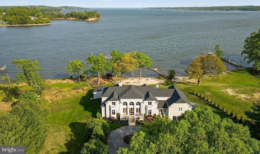 Experience luxury living in this stunning 11,000+ square foot home, nestled on 3.2 acres with over 300 feet of waterfront. Located just 30 minutes from Baltimore and Annapolis, this estate offers expansive, unobstructed views of Broad Creek, the Magothy River, and the Chesapeake Bay. At approximately $400 per square foot, it’s like getting the exceptional waterfront for free!

The walkout lower level, an entertainers paradise featuring a home theater/game room, bar/family
room, gym, and bedroom with en-suite bath, leads to a covered patio with dining for 16, pool house
with one full and one half bath and a dockside garage, and an outdoor kitchen overlooking the in-ground
pool and spa, private beach, 210 foot pier with three slips and a lift (previously providing dockage to a
53’ Hatteras Motor Yacht, 40’ Sea Ray, and a 23’ Mako center console).

Upon entering the grand foyer with curved staircase and soaring ceilings, guests are drawn to the
expansive waterfront views from the adjacent, and equally grand, living room. The east wing contains a
private office, half bath, and primary suite with ensuite bath. The west wing hosts a large eat-in kitchen
with sitting room, dining room, half bath, laundry/mudroom, access to the 4-car garage and immense
bonus room above, and backstairs to the lower and upper levels. Between the wings you’ll find a large
upper deck designed for entertaining.

Up the curved staircase you will find an open central hall overlooking the foyer and living room below,
four spacious bedrooms, two full baths, and a second laundry room.
Built in 2000 this property redefines privacy, ensuring a secluded and independent lifestyle, close to
everything but off the beaten path. Propane powered spa, hot water, dryer, cooktop, and furnaces
keeps utility bills in check. The propane fueled whole house generator ensures uninterrupted power.
With no HOA you have the freedom to live your life your way. The new roof (2022) and exterior (2024)
provide maintenance free living for decades to come.

This estate is a must-see for those who crave a water-oriented lifestyle, wide open spaces, large rooms,
magnificent windows with expansive views, and high ceilings--not to mention truly exceptional
waterfront. Schedule your private tour today!
