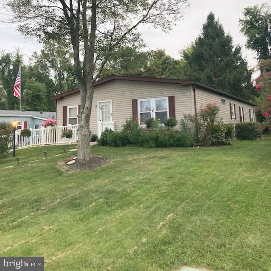 This home is located in a 55+ complex called Neshaminy Falls in North Wales Pa. It is a 2 bedroom, 2 bath unit with a 12x15ft  carpeted entry room.  The living room follows with a wood burning fire place. The master bedroom  is fully carpeted and has a private bath with a large  walk in shower. The carpeting in all the rooms is less than two years old. The dining room, hall and back room have new wood laminate flooring. The back room has a full length closet and can be used as a 3rd bedroom or perhaps an office. This room  has double glass sliding doors with screening leading out to a 12ft x16ft. deck which looks out to a wooded area lending to privacy. There is also an 8x8ft shed at the back of the home. The kitchen comes with dish washer and fridge. Clothes washer and dryer are located in the hall. Central AC with electric heating.