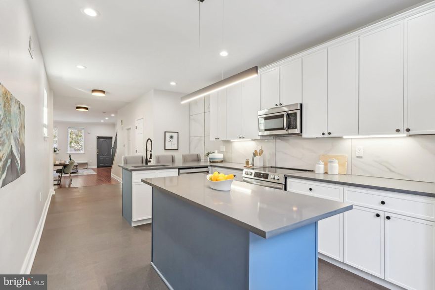 1714 Federal Street, Philadelphia, PA is where contemporary design meets comfortable living at the north end of Point Breeze. This spacious 4-bedroom, 3.5-bathroom home for sale is a masterpiece, offering 2,700 square feet of thoughtfully designed living space. And with the home’s impressive 16' x 73' lot size, you’ll enjoy a feeling of spaciousness that’s rare in the city. You’ll be captivated by the rich hardwood floors that extend through the home. The open-concept living and dining areas flow effortlessly into the heart of the home—an expansive, newly designed kitchen that features slim shaker cabinetry, sleek quartz countertops, and a striking blue island. The kitchen Peninsula features a breakfast bar.  Equipped with stainless steel appliances and bathed in natural light from the adjacent sliding glass doors, this kitchen is perfect for cooking, entertaining, or just enjoying a quiet cup of coffee. Step outside to the large, private outdoor patio—ideal for summer barbecues, dining al fresco, or simply relaxing with friends. The custom wood fencing and ample space for furniture or plants make this an outdoor retreat you’ll love year-round. Southern exposure makes this a great area for container gardening. On the upper levels, four generously sized bedrooms await, each designed with comfort in mind. The 2nd-floor hall bathroom features a spa-like ensuite bathroom with bold blue tiles, dual vanities, and modern fixtures that exude sophistication. Each bathroom in the home has been designed with impeccable attention to detail, showcasing chic tiles and fixtures that elevate the spaces to the next level of luxury. The third floor features two bedroom suites each with an ensuite bathroom. The front bedroom suite includes a terrace with views of the city. The semi-finished basement is a perfect place to store all of your things out of sight.  Location is everything, and this home doesn’t disappoint. You’re just steps from Washington Avenue’s vibrant mix of shops, gyms, and grocery stores, including Sprouts, Target, and the local wine and spirits store. This neighborhood buzzes with energy, offering countless options for dining out or meeting friends at trendy cafes. Rittenhouse Square, Passyunk Square, and Graduate Hospital are all steps from this home. With its prime location, modern amenities, and abundant charm, this home offers a lifestyle that blends urban convenience with the warmth and privacy of your city retreat. Schedule your showing today and see for yourself why this property is the perfect place to call home. Move-in, Unpack, EnJoy!