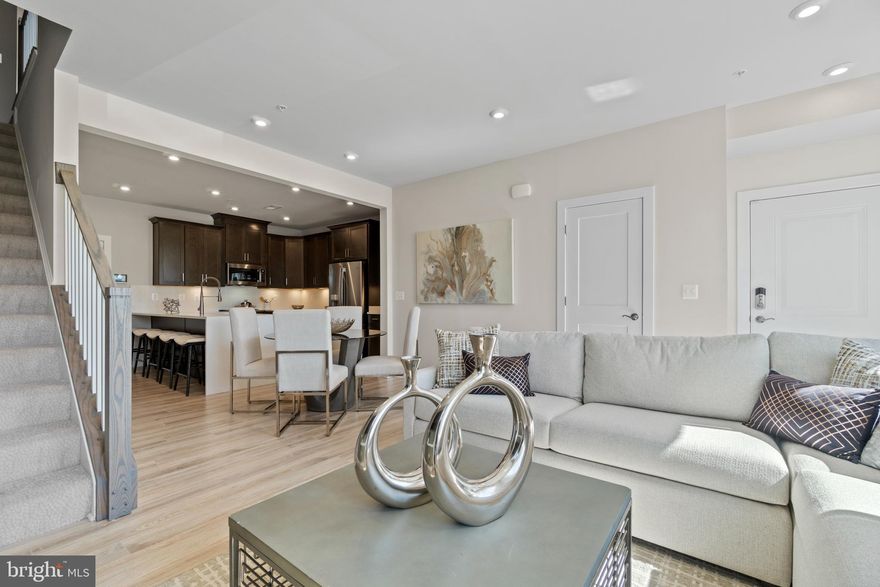 Brand new Stanley Martin townhome-style garage condo. The open-concept design of The Tessa allows for ease of living and entertaining from the kitchen to the main family room whether that means a casual dinner on the couch or hosting happy hour with friends. The front of the condo has three large windows allowing for natural light to flood the space, making it feel even more spacious and open.
The family room is large enough for a 5-8 person sectional and is connected to the dining space and kitchen. For a 2-bedroom condo, the kitchen is built to impress. The quartz countertop peninsula provides seating for 5 and plenty of space to lay out appetizers and snacks or to have quick meals while you’re working from home.
The oversized primary suite on the second floor is big enough to make you feel like you’re in a single family home. It has an en-suite bathroom, double vanities, two walk-in closets, and a private water closet. Next to the other bedroom on the second level you will find a loft/bonus space with a deck, perfect for a work from home office space or a second living space. Photos shown are from a similar Tessa. Schedule your tour or stop by and visit the model homes today. Only a few homes remain in the neighborhood!

With convenient access to shopping, dining and entertainment combined with proximity to several major commuting routes, Ashbrook Place is an ideal choice for anyone who wants to work and play close to home.Meet friends for drinks at a lively happy hour spot, spend quality time with family at TopGolf and the Alamo Drafthouse Cinema, or spend Saturday mornings strolling through the farmer's market with a freshly brewed cup of coffee. It’s more than you could ever want, and it’s all right here in Ashburn! Visit us today!