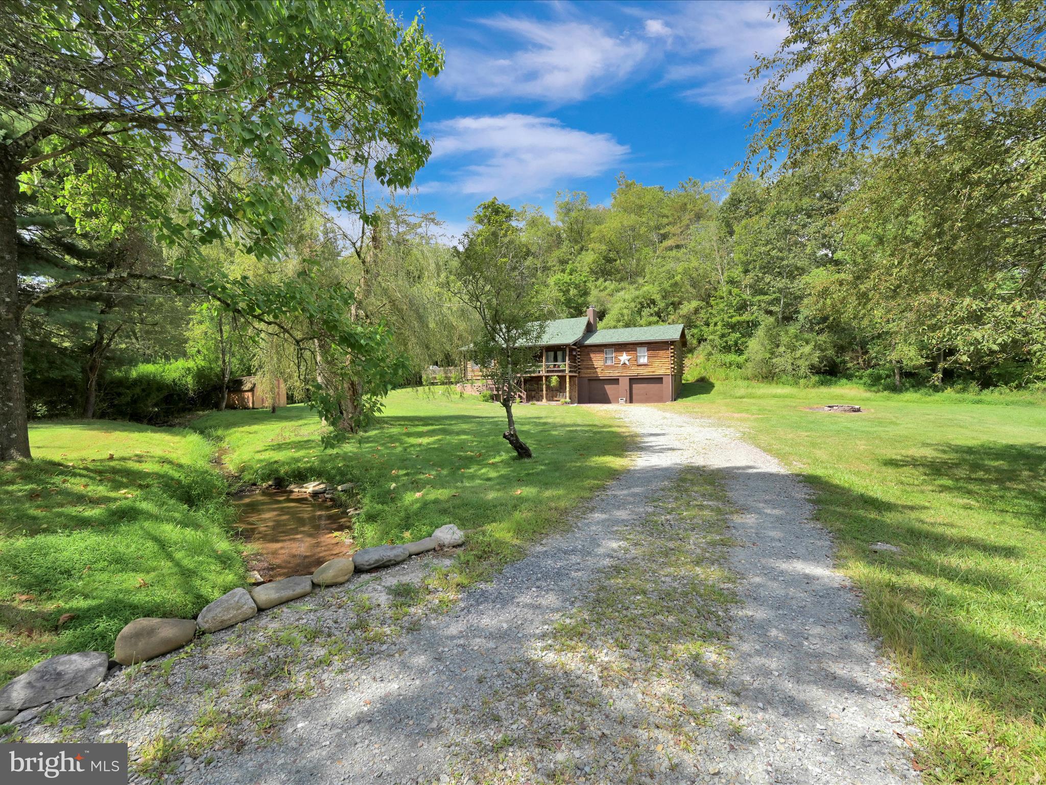 Just in time for archery season! Serenity awaits at 26 Chain Circle in New Ringgold! Enjoy peaceful country living in this large log home of over 1,800 square feet above grade, featuring an open floor plan with 3 bedrooms and 1.5 baths on the main level and 2 large bedrooms on the second floor. The lower-level walk out basement is unfinished (except for a recently updated 2nd full bathroom) but is prepped with framing and electric for future finished living space. You will find wood floors throughout both the main and upper levels while granite counter tops and newer stainless-steel appliances adorn the bright and cheery eat-in kitchen. The primary bedroom is one of the three bedrooms on the main level, and it does have a recently updated private half bath of its own. The other full bath on the main level features a tiled shower stall and double sink vanity that has also been recently updated. The boiler features 3 zones via hot water delivery and heats the entire home nicely but if you wish to save on oil, the wood stove does a fantastic job of heating the whole house comfortably as well. Relax to the sounds of your very own babbling brook out front either from the elevated front porch or the two-tiered expansive deck to the side of the home. There is plenty of parking with the integral two car garage and the long drive with extra space for more vehicles if needed. A new roof was installed in September of 2023. All of this nestled on a lovely 2 acre lot with abundant wildlife to watch. If you have ever dreamed of your own log home, now is your chance to make that dream a reality. Being sold as-is with no warranties expressed or implied.