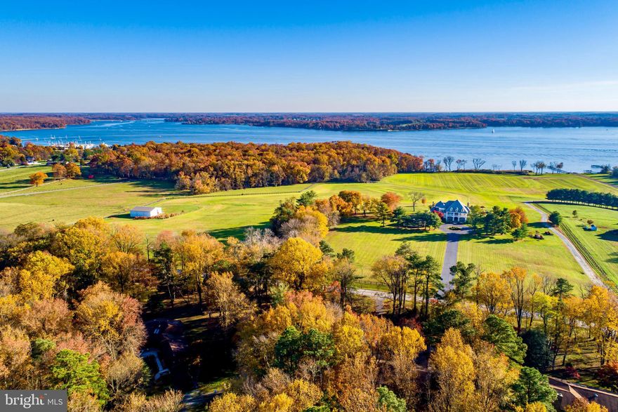 From NYC to the peace & quiet of the Chesapeake Bay shores in  2.5 hours via the Amtrak Acela to Wilmington, DE. PHL International Airport - 60 min drive; Summit Aviation Private Jet Services - 20 min drive; Wilmington Amtrak - 30 min drive. Perfectly located atop a gently sloping hill with commanding water & countryside views, this beautiful & timeless home overlooks the shimmering water of the Bohemia River. Offered for the first time, no detail has been overlooked in this meticulous custom-built home. The main home features 5 spacious bedrooms, 5 full baths, 2 half baths, 4 fireplaces, 2 gourmet kitchens, & an 18-seat home theater. Premium hardwood floors, custom arched millwork cabinetry & built-in shelves, & multi-level covered balconies both on the front & waterside of the home. The open flow of the main level makes for easy entertaining. A gourmet kitchen with a Wolf range, 2 Sub-Zero refrigerators, double drawer dishwasher, an oversized island, & a fully equipped butler’s pantry is the heart of the home. The family room with coffered ceiling has large windows offering an abundance of natural light & sweeping water views. A stone fireplace brings warmth to chilly evenings & ambiance to any gathering. Glass doors along the back of the home open to a partially covered bluestone patio. The main level Primary or Guest Suite sits privately at the far end of the home, with a cozy gas fireplace sitting area, large windows, a luxury en suite bath, & French doors which open to the waterfront bluestone patio. A graceful turned staircase, the epitome of expert craftsmanship, accesses each level of the home. The upper level Primary Suite is a serene retreat unto itself. Consisting of over 1300 sq ft, this beautiful space offers a bedroom area, sitting area with gas fireplace, luxury bath - which includes a powder room with bidet, jetted soaking spa, dual head glass & tile shower, dual vanity, & custom cabinetry, 2 expansive walk-in closets, as well as a morning kitchen with a spa exercise room. A nearly 50' long covered porch & sun deck has panoramic water views to relax, exercise, or simply enjoy the tranquility of a stunning Chesapeake Bay sunset. 2 additional bedrooms with en suite baths & covered balconies share this level. A laundry room with drip-dry area for swimsuits/clothing is at the top of the staircase. The open flow continues on the lower level with a full kitchen, living & dining spaces, while high ceilings & custom woodwork create a seamless flow with the upper levels. The 18-seat theater, with fully reclining seats, 120" screen, & theatre surround sound make for an incredible experience. The lower level bedroom suite, with a walk-in closet & Jack & Jill bath, is currently used as a large  playroom with storage for games & toys. A 12' long walk-in pantry with dumbwaiter transports backup staples, seasonal décor, or large kitchen appliances with ease to the upstairs main kitchen. Step outside & take in the fresh air where the multi-tiered bluestone patios lead to a built-in grill area, sunbathing platform, & an oversized in-ground pool. Relax poolside while the children happily splash about in the adjacent in-ground wading pool. The extensive patio has wide open views of the gently rolling topography of this 54+ acre property. The 46’ x 60’ climate controlled, finished barn with a 2,700 sq ft apartment is located on the drive to the waterfront. The barn’s climate-controlled open space has concrete floors & a high ceiling, ideal for a workshop. It is also the ultimate space for hosting a party, with a restroom, an elevated DJ booth, retractable screen, & projector. Upstairs features a great room with high ceilings, reclaimed wood beams, hardwood flooring, 2 bedrooms, a full bathroom, granite countertop kitchen, & oversized windows overlooking the water. An additional 3000 sq ft building is perfect for property maint equipment, boat, jet ski, golf cart, & ATV storage.