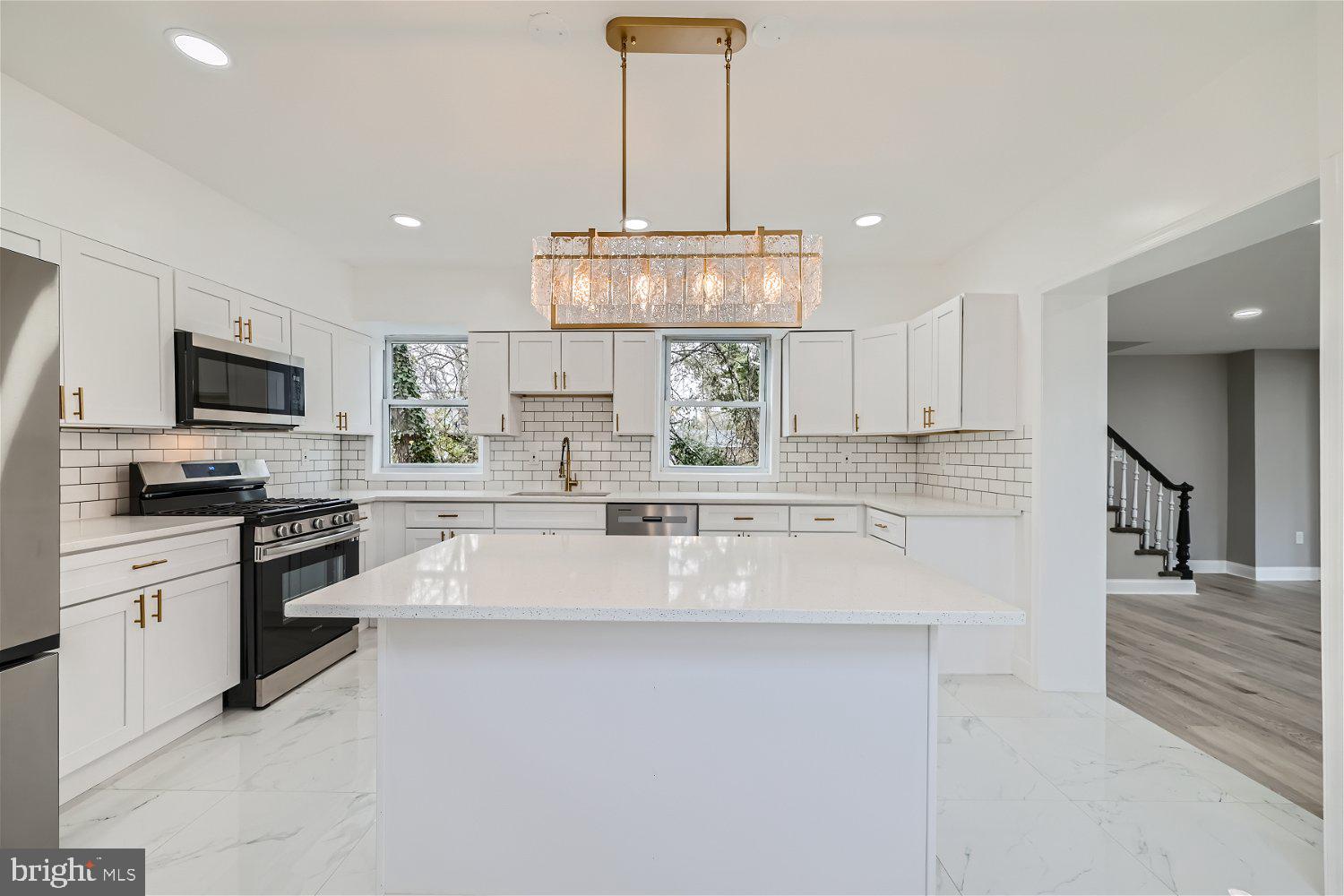Fresh new landscaping makes this house stand out. Nestled towards the back of the lot, this recently renovated home provides for a large front yard to play, party, and boasts a driveway for onsite parking. Large kitchen with stainless steel appliances, quartz counter tops, immaculate gold touches, large island, and plenty of cabinet space. Pergo flooring throughout the expansive dining and living room. Electric fireplace creates a cozy vibe in the living room. Open floor plan. First floor full bathroom. First floor laundry room. Three large bedrooms upstairs. Large full bathroom on second floor. Plastic fence at the rear of the house. Schedule your appointment and check out this gem.