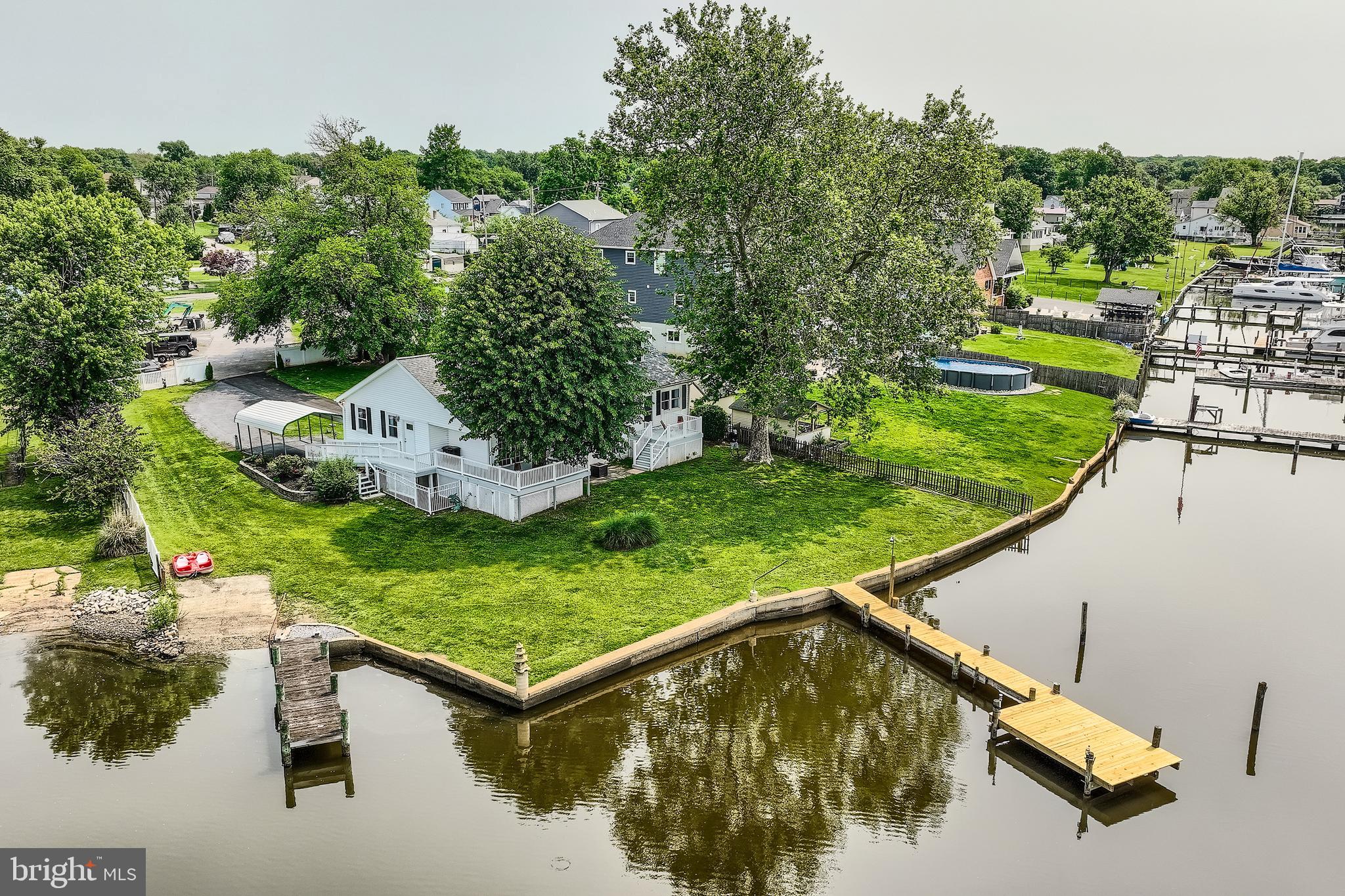 Breathtaking Waterfront Retreat on Jones Creek! Welcome to your private oasis in the heart of Sparrows Point, a rare opportunity to own a spectacularly renovated single-family home offering approximately 140 feet of panoramic waterfrontage on .33 acres of pristine shoreline. This stunning property features two piers, a private boat ramp, and breathtaking views from nearly every room, creating the ultimate waterfront lifestyle experience. Step inside to a light-filled foyer with immediate water views, a convenient half bath, and laundry room. The open-concept main level invites you into a gourmet chef’s kitchen complete with granite countertops, under-cabinet lighting, stainless steel appliances, cooktop, built-in oven and microwave, crisp white cabinetry and stunning backsplash. The large kitchen bar offers plenty of seating, and the adjacent dining area flows effortlessly into a spacious living room with a cozy sitting nook, all designed to showcase stunning water views. From this space, step out onto the first of two expansive decks, where you can soak in the waterfront breeze and take in truly unforgettable views. The upper level features two generously sized bedrooms and a beautifully updated custom tiled full bath. What makes this property truly unique is its flexible layout, ideal for large families or multigenerational living. Off the main living area, a separate wing includes a massive family/rec room/dining area with vaulted ceilings and sliding glass doors that lead to a second waterfront deck, perfect for entertaining. Here, you'll also find a luxurious full bath with a jetted tub and custom-tiled walk-in shower, and an exceptionally renovated second kitchen, never used, all brand new, featuring vaulted ceilings, granite countertops, white cabinetry, stainless steel appliances, custom backsplash, a spacious bedroom with walk-in closet, all with water views and a private upper-level bedroom complete the space with brand new egress skylight window, flooding the space with natural light! This wing offers its own separate entrance with a ramp, making it ideal for an in-law suite, guest quarters, or private family living. Throughout the home, you’ll find all-new luxury vinyl plank flooring, blending durability with high-end design. Additional highlights include an attached garage, a spacious driveway, a covered carport, and a partially fenced yard. The recently waterproofed basement offers an oversized storage area for all your needs. This home boasts two dual HVAC systems for efficient climate control, a 6-year-young roof, a new main pier with fresh decking, new pylons and electrical hookups. A second pier, just five years new, complements the property, both ready to accommodate your boat, jet skis, or simply enjoy peaceful waterfront living. And when you’re ready to explore, hop on the paddle boat for a magical ride along the creek, just minutes from the brand-new Sparrows Point Park. Enjoy a full day of activities, from playgrounds and scenic walking paths to storytime and music & movement for your little ones, as well as activity rooms, a community center, athletic fields, and so much more, all just minutes from your dock. Whether you're entertaining on the dual decks, launching a boat from your own ramp, or simply unwinding by the water, this exceptional home delivers a lifestyle few can match. A true waterfront gem-inside and out. From boating adventures to sunset dinners on the dual decks, or simply unwinding with the gentle sounds of the water, this exceptional property invites you to live the waterfront lifestyle to the fullest. Truly a rare find, where comfort, beauty, and location meet. So, what are you waiting for? Come take a tour, fall in love, and make this enchanting waterfront retreat the next chapter in your story!!!
