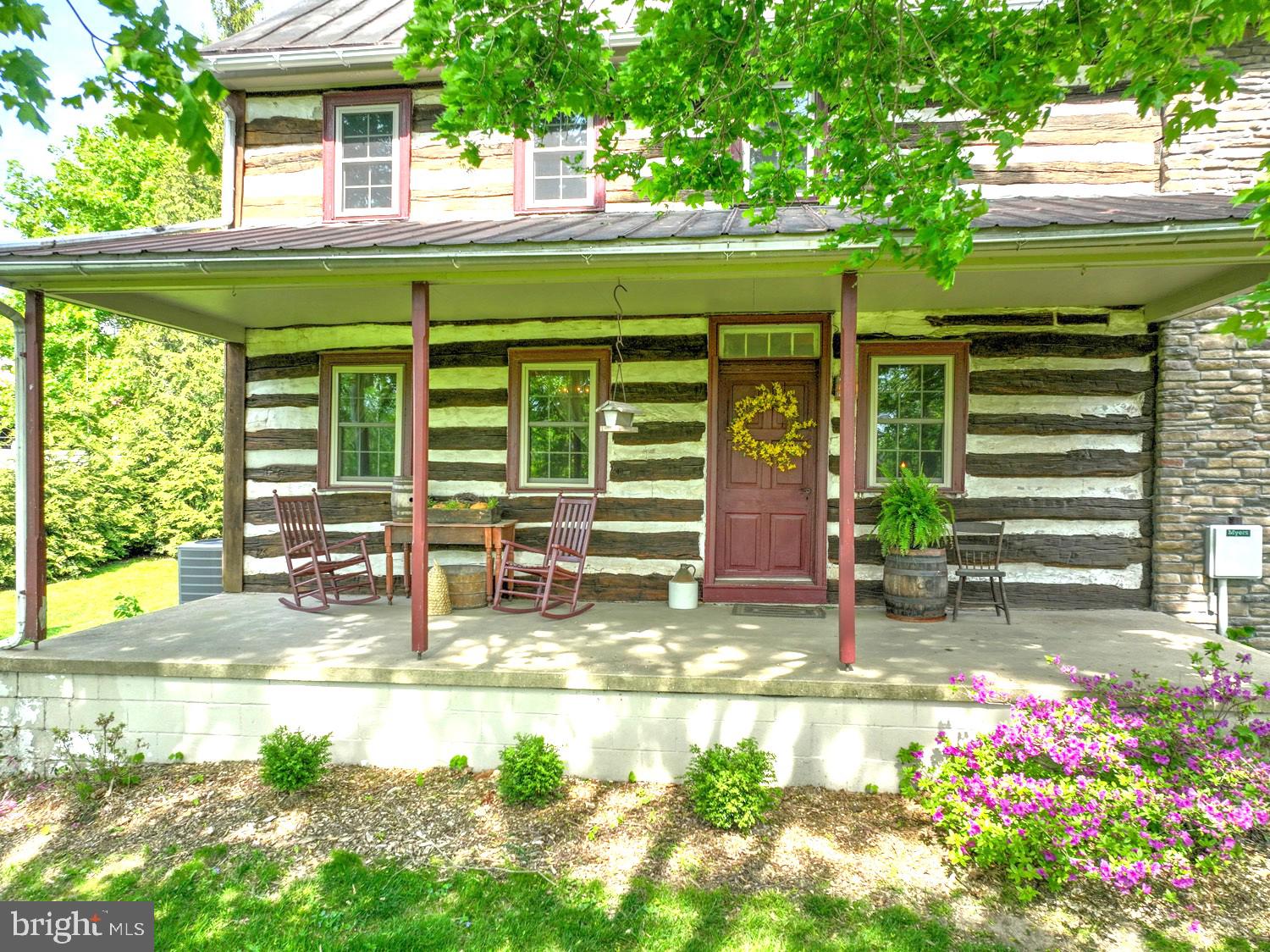 THIS PROPERTY IS GOING TO AUCTION ON WEDNESDAY JUNE 4, 2025 @ 6:00 PM. THE LIST PRICE ONLY REFLECTS THE SUGGESTED STARTING BID. Completely renovated "Log Cabin" style house while keeping all its history charm including a 3-year old addition integrated into the same time period. It feels like a museum but includes all the current comforts to make it more day-to-day friendly. The original part of the house was built between 1790-1800 with a later kitchen addition and third spacious addition in 2022, it's like stepping back in time. Kitchen/dining cabinetry incorporated old cupboards and wooden boxes to fit the time period, includes all stainless steel appliances. 2022 great room addition is post/beam construction, fireplace mantle, 15' cathedral ceilings, powder bathroom, adjoining room with remarkable walk-in original stone fireplace, living room with log walls, laundry room with sink. Inviting front and rear covered porches, 20' x 6' rear concrete patio. Second level has 3 bedrooms, landing area, primary 11.5' x 9' walk-in closet, full bathroom with shower. Two new heat pumps and A/C in 2022, central vac. Detached garage is a concrete block 28' x 40' garage/shop, plenty of room for vehicles. 1-12' x 9' overhead door and 1-9' x 7' overhead door, concrete floor, electric service. This is a rare opportunity to live in a "Log Cabin" style house restored in all its glory with modern amenities for luxury living. Property has a large pond beside the road so the buildings can set back away from traffic. Truly a must-see property if you enjoy the "Late Revolutionary" part of American history.