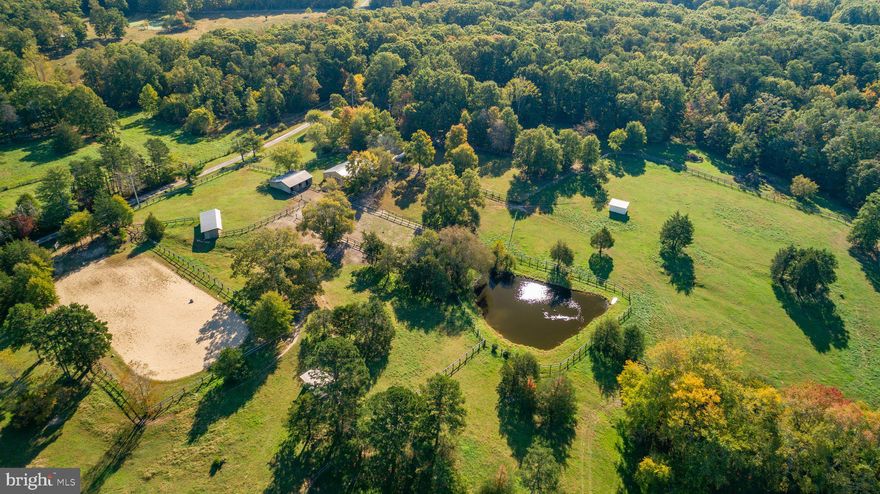 Welcome to Wedgewood Farm! Situated just 13 miles from I-95 & within an easy drive of both Fredericksburg & Warrenton, this equestrian haven is ready for new ownership & offers many opportunities. This 20.21 acre property is comprised of 2 separate parcels being conveyed as one. The equestrian features & amenities are detailed below but begin your tour at the farm house. Plenty of parking is available on the side of the home - for owner, boarders, & guests. Built in the 1970's, with many changes & upgrades along the way, this comfortable tri-level home offers flexibility in living space and/or clinic, office, or in-law opportunities. Enter the home by way of the wide front porch steps and come in to explore. Freshly painted with new carpet, this home is ready for your decor.  On your right is the kitchen featuring light oak cabinetry, SS range hood, fridge with ice-maker, wall ovens & cooktop - check out the view of the barn from the window above the kitchen sink. There are pull out pantries for dog food, and lots of cabinet storage. The living room &  dining room have large windows to enjoy the view of the backyard, where horses like to stretch their legs. A large screened porch offers a relaxed space to entertain at the end of the day. The living room features a great potbelly wood stove for cold winter nights. Head upstairs to find 3 spacious bedrooms, a hall bath, and the primary bedroom (BR #4) with dressing area & bathroom. The hall bathroom has a tub and a convenient half door into the upper crawl space for storage. Downstairs is the oversized family room with lots of built-ins, a desk area, a half bath, under stair storage, & more closets. A second wood stove makes this room cozy -- perfect for large gatherings. Head around the corner to find your farm office with built-in desk, great for managing the day-to-day tasks like shows, farm records, etc... The laundry/utility room is adjacent to this with a door to head out to the backyard. The panel to the 3/4 house Generac generator is also located here. Finally, the in-law addition has so many possibilities. Designed with ADA accessibility, it has a separate entrance with gently sloped ramp at the front of the house, plus a rear door to its own private deck. This space is perfect for a guest, with counter space for meal prep, dining, bedroom #5, a roll-in shower, & living area. Two sheds - one oversized - will store tools, equipment, and toys! The possibilities here are endless. 
**Wedgewood Farm Features:**
- **Acreage:** 20.21 acres with extensive perimeter & cross-fencing
- **Equestrian Amenities:**
  - 3 **Run-In Sheds** for horses' shelter
  - **Riding Ring** for training and riding activities
  - 3-Bay **Equipment Shed** (wired to the main house, ideal for equipment parking or a workshop)
  - 6-Stall **Main Barn (New Barn)** equipped with:
    - Heated tack room with hot/cold water
    - Rubber stall mats, water heater, and refrigerator
    - Separate well with Mermaid filtration system and electric meter 
    - Metal-lined feed bins
    - Ceiling fan wiring throughout the barn
    - Misting system with expansion capability
  - **Grooming Stall**
   - 3-Stall **Old Barn** with electricity and rubber mats + hay storage 200 bales  
- **Mare and Foal Paddock** for safe quarantining
  - **5 Large Pastures** and **5 Re-configurable Paddocks**
  
- **Arenas:**
  - **Fenced Sand Riding Ring:** 100' x 200', suitable for equestrian competitions and shows
  
- **Additional Property Features:**
  - **Spring-Fed Pond**: Fed by 3 natural springs with regular service from Solitude Lake Management
  - **Fencing:** 5' tall, three-rail perimeter fencing with rounded corners and 4' tall, two-rail cross-fencing
  - **Lightning Rods** on both barns

This premier equestrian facility, Wedgewood Farm, is thoughtfully designed for both functionality & comfort, catering to all the needs of horse enthusiasts!