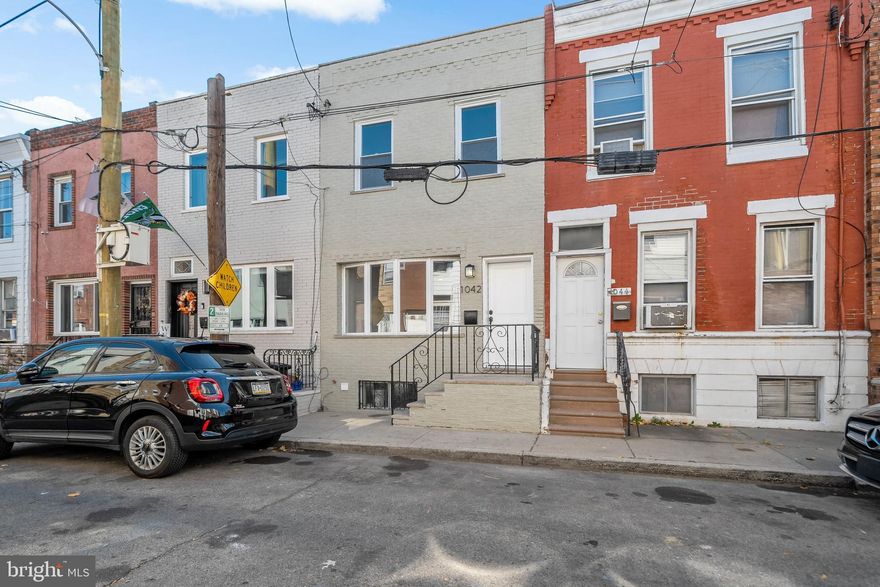 Welcome to 1042 Emily Street, a meticulously renovated gem in the vibrant East Passyunk neighborhood. This inviting 2 bed, 1 bath home has been thoughtfully designed to offer modern comfort, style, and convenience. Step inside and you will immediately be greeted by the natural light streaming through the front bay window, highlighting the beautifully installed new flooring that flows throughout the home. The open-concept living and dining areas offer a seamless space for entertaining or simply relaxing at home. The heart of the home is the upgraded kitchen. Featuring sleek custom cabinetry, new tiled backsplash, and top-tier GE appliances, it combines functionality with flair. A standout feature is the built-in coffee bar with a wine fridge, perfect for morning routines or evening unwinding. Upstairs, the spacious bedrooms are bathed in natural light and offer ample closet space. The fully updated bathroom has been styled with contemporary fixtures, creating a spa-like oasis to start or end your day. This home has been revitalized from the ground up with new solid-core doors, widened basement stairs, and custom railings. Major upgrades include a completely new roof, sheetrock, framing, subfloor, and an updated electrical and plumbing system for ultimate peace of mind. Situated on a welcoming street, this home is just steps from East Passyunk Avenue's eclectic restaurants, boutiques, and cafés. With every modern touch and thoughtful detail already in place, this home is truly move-in ready. Schedule your showing today to see all that 1042 Emily Street has to offer. This is your chance to own a beautifully updated home in one of Philadelphia’s most sought-after neighborhoods!