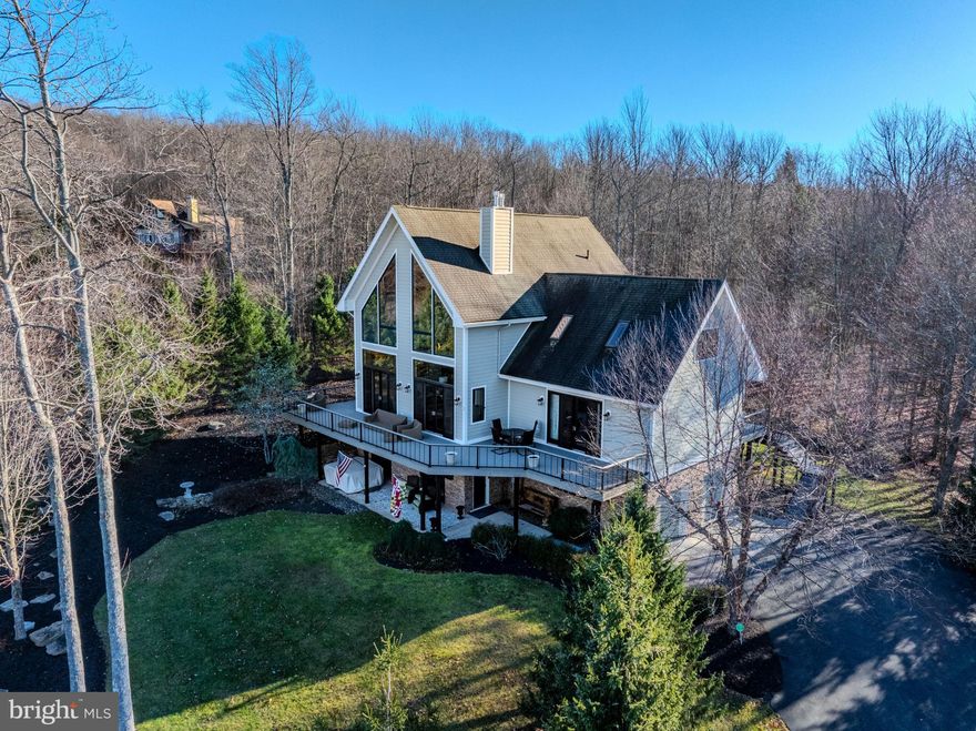 Welcome to 444 Woodlands Hill Ln, in Oakland, MD.  Nestled in the private community of The View, this custom home offers stunning lake views in a serene, private setting.  Centrally located less than 4 miles from Wisp while backing up to hundreds of acres of untouched forest, this property truly offers the best that Deep Creek Lake has to offer.  This luxury home has been impeccably maintained as a second home, and has never been used as a rental property.  No expense has been spared as this home boasts four master suites, two gas fireplaces, a saltwater hot tub with lake views, 10' ceilings throughout, and a newly built, 2,000 square foot custom composite deck complete with an underdeck drainage system for extra dry space for entertaining.  Utilities include a 2-zone HVAC system with an additional mini-split system that supplies the master suite and bonus 4th floor loft.  This home is complete with a whole-house water filtration system, Moen Flo auto shut off system, and integrated gas lines to the outdoor grill station.  A custom stone surround spans the foundation of this home and years of carefully planned landscaping leads to a massive outdoor firepit area behind the property.  With fresh paint, new carpet, updated siding, and upgrades galore, this home is truly a must see!