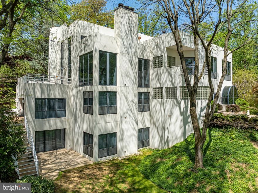 Welcome to this stunning contemporary masterpiece, custom-built by Bowser Construction, showcasing breathtaking architecture and a design that seamlessly blends luxury, functionality, and nature. Constructed with commercial-grade steel, cinderblock, and windows, this home offers unparalleled durability and style. Nestled on nearly 3 acres at the edge of the woods in a private and serene setting, the property is surrounded by nature’s beauty, with abundant wildlife and panoramic views through its extensive commercial grade windows. The open floor plan and soaring 29-foot ceilings in the great room create a bright and inviting atmosphere, perfect for entertaining or simply enjoying the tranquility of your surroundings. This expansive home features 5 bedrooms, 4 full bathrooms, and 4 half bathrooms, with custom finishes like extensive marble accents, abundant built-in planters, two spiral staircases, and several glass block windows that add a touch of modern elegance. The cozy living room boasts a wood fireplace and picturesque views of the woods, with an attached bar room ideal for hosting gatherings. The luxurious primary suite is a true retreat, featuring a tray ceiling, gas fireplace, sitting area, generous walk-in closet, and a tranquil en-suite bathroom with a jetted tub. Additional highlights include an indoor spa with a hot tub and a full bathroom, a gourmet kitchen with granite countertops and electric appliances, and a family room with another wood fireplace and an attached billiards/game room bathed in natural light. The fully finished basement offers versatile spaces, including an art studio, recreation room, and a theater room, providing endless opportunities for hobbies or relaxation. Located in a highly accessible area, this property is ideal for those seeking a blend of modern luxury, comfort, and a connection to nature. Don’t miss the opportunity to make this architectural gem your home!