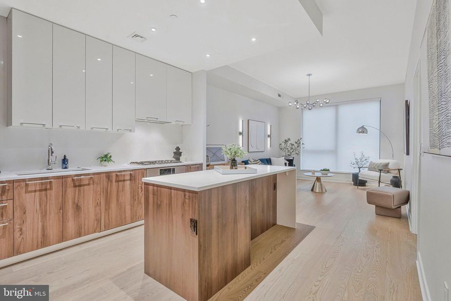 Elevated, light-filled, and priced to sell! Welcome to this 17th-floor residence at The Verse in the heart of The Boro. Flooded with sunlight from south-facing windows, the home offers sweeping treetop and city views.

The open layout feels expansive with soaring 10-foot ceilings and contemporary finishes. The designer kitchen blends style and function with custom cabinetry, composite stone countertops, and a dramatic waterfall-edge island with seating and extra storage. Premium appliances include a five-burner gas cooktop with wall oven, concealed refrigerator and dishwasher, built-in microwave, and full-height pantry.

The spacious bedroom provides a calming retreat with upgraded custom closet systems. A separate den offers flexibility for a home office, workout space, or guest area. The spa-inspired bath features porcelain Calcutta marbleized flooring and tile surround, complemented by a custom vanity and built-in linen storage.

One reserved garage parking space (#125) conveys for added convenience.

The Verse offers a full-service lifestyle with 24/7 concierge, automated package system, secure resident garage, guest suite, pet spa, bike storage with repair station, EV charging stations, and preferred low-emission parking.

Residents enjoy the one-acre SkyPark with lawn space, grilling stations, fire pits, outdoor dining areas, and landscaped courtyards. A resort-style pool, fully equipped fitness center, yoga studio, and outdoor zen terrace complete the amenities.

Steps from Whole Foods, acclaimed restaurants, boutique shopping, and seasonal farmers markets, and less than one mile from Greensboro and Spring Hill Silver Line Metro stations, this home offers unparalleled convenience.

An exceptional opportunity in one of Tysons’ premier luxury buildings, priced to sell!