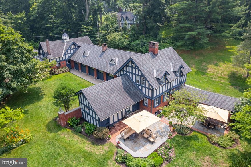 “Meadow Lodge” is a magnificent one-of-a-kind English carriage house to the neighboring Robert E. Strawbridge Estate, built at the turn-of-the-century. Charmingly unique with old-world heritage which communicates in the European touches within the home; has been professionally renovated throughout and is in mint condition with exquisite decor. The beautifully secluded property with professionally landscaped grounds includes a slate patio with sitting wall, and is embraced by an historic stone wall. This historic home has been thoughtfully updated while maintaining the beautiful original millwork and hardwood floors. The open concept main level floor plan includes a brand new kitchen featuring a Viking range, quartz countertops, solid wood cabinet doors and drawers, stainless appliances, and tile backsplash. The family room boasts the original carriage doors and a wood fireplace with wood mantle. The main-level primary suite includes four spacious closets with built-ins, carriage doors, and an ensuite bathroom with quartzite top double vanity, beautifully tiled shower, and a soaking tub. Love to entertain? The renovated loft is the perfect gathering place for your guests, and includes a vaulted ceiling with exposed beams, a full bathroom, and a fully equipped second kitchen including a wine refrigerator. French doors open to a peaceful balcony. The unique home is very private yet minutes from downtown Bryn Mawr and Wayne with easy access to the train lines and highways to Philadelphia or the airport. Don’t miss this rare opportunity to own a piece of Main Line history – call for your private showing today!