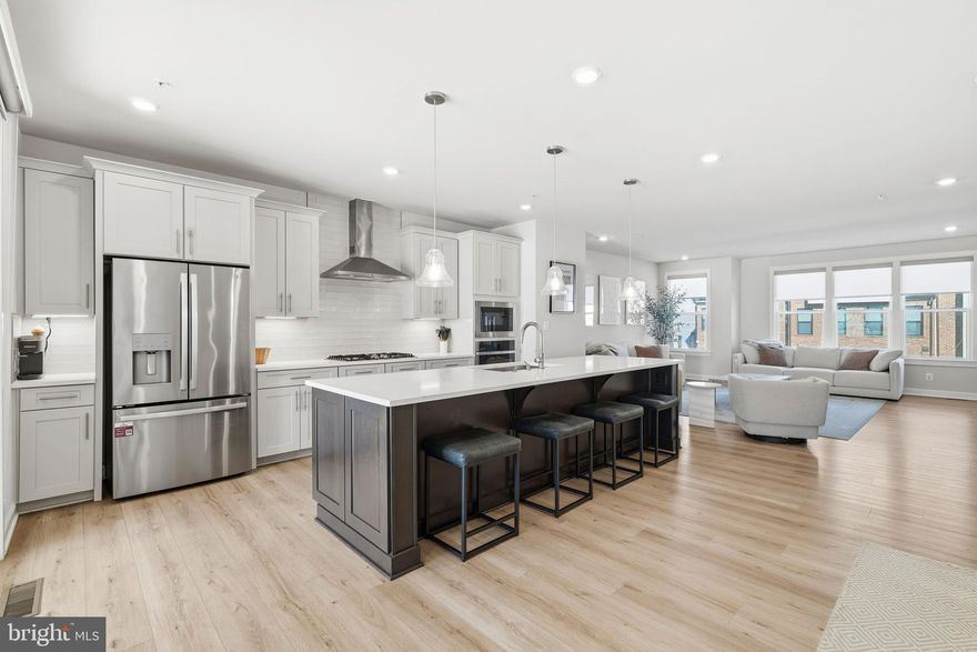 Welcome to the Woodley Park model, built in 2023 and perfectly situated in the highly desirable Hunt Valley community. Perched above Hunt Valley Towne Centre, this home offers convenient access to top-rated schools, downtown, major highways, and BWI Airport. Inside, you’ll find an array of premium upgrades throughout. The main living level showcases an open-concept design with a spacious great room, dining area, a half bath and a chef’s dream kitchen featuring top-tier Calacatta Ultra Quartz countertops, premium cabinetry, and a 4CG appliance package that includes a 36” five-burner gas cooktop with separate wall oven, 4TG French door refrigerator, and stylish glass globe pendants. Enhancing both beauty and function, the kitchen also includes 12 added under-cabinet LED lights, four additional 110v outlets, and a Raku White backsplash that ties the space together elegantly. The flooring selections elevate every room, with 7.87’ Bruce Rigid Core planks in Beachside Warmth gracing the kitchen, powder room, great room, and laundry area. The foyer tile and carpeting throughout the basement and third floor are all top-tier selections, offering both luxury and durability. Step outside to the expanded lanai, upgraded with a gas fireplace, partial brick surround, and a 4-foot porch extension—a perfect space for entertaining or quiet relaxation. Upstairs, the home continues to impress with three bedrooms and two full baths, including a luxurious primary suite that features an upgraded Contessa Dama 13x13 tile in both the walls and floors of the master bath, creating a serene spa-like retreat. The entry level provides a welcoming foyer with upgraded tile, a recreation room, another half bath, and an attached garage—combining functionality with thoughtful design across all three levels.