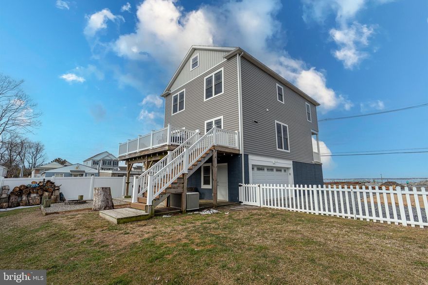 Welcome to this scenic, double-sided water-view Coastal-style home nestled in the highly sought-after Miller’s Island community, where bay and river views create the perfect backdrop for everyday living. Thoughtfully designed and impeccably maintained, this 4-bedroom, 3.5-bathroom home blends modern comfort with relaxed coastal charm—plus fully owned solar panels that offer monthly energy credits and reduced utility costs.
Step inside to an open floor plan featuring 9-foot ceilings, crown molding, and sun-filled spaces that flow seamlessly from room to room. The gourmet kitchen boasts smudge-proof stainless steel Energy Star appliances, a wrap-around peninsula with ample seating, and opens effortlessly to the adjoining dining area, highlighted by oversized windows that show off the brilliant views. The living room is warm and welcoming—ideal for everyday living or entertaining.  Step outside to enjoy a beautiful elevated deck overlooking a patio with a built-in fire pit, perfect for evenings under the stars. 
If you need to host a large party or split up for your two favorite shows, a separate oversized family room offers additional gathering space and includes a walk-in storage closet for added functionality.  There is more space than you could possibly need!
The primary suite is a true retreat, featuring a spacious walk-in closet and a luxurious en-suite bath with a custom tiled walk-in shower and double vanity. Curl up with a good book and take in peaceful bay views from the oversized bedroom windows.
Three additional bedrooms and a full bath with tiled flooring and tub/shower complete the third level, along with convenient upper-level laundry.
A full-size walk-up staircase leads to an impressive 8’ x 40’ attic, offering storage galore or the potential for an additional bedroom or flex space—all while enjoying stunning views of the bay on one side and the river on the other.
At ground level, you’ll find a versatile recreational or additional family space with a full bathroom—perfect for guests, hobbies, or entertaining. Additional storage closets, including a walk-in area connected to the attached two-car garage, ensure everything has its place.
Designed for gatherings, celebrations, and everyday enjoyment, this home offers a rare opportunity to experience coastal living with a close-knit community feel, all while being just steps or a bike ride away from local restaurants, parks, and waterfront attractions. Enjoy the charm of down-home coastal living with the convenience and energy of nearby city life.