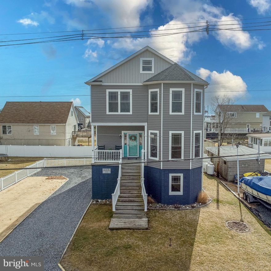 Welcome to this scenic, double-sided water-view Coastal-style home nestled in the highly sought-after Miller’s Island community, where bay and river views create the perfect backdrop for everyday living. Thoughtfully designed and impeccably maintained, this 4-bedroom, 3.5-bathroom home blends modern comfort with relaxed coastal charm—plus fully owned solar panels that offer monthly energy credits and reduced utility costs.
Step inside to an open floor plan featuring 9-foot ceilings, crown molding, and sun-filled spaces that flow seamlessly from room to room. The gourmet kitchen boasts smudge-proof stainless steel Energy Star appliances, a wrap-around peninsula with ample seating, and opens effortlessly to the adjoining dining area, highlighted by oversized windows that show off the brilliant views. The living room is warm and welcoming—ideal for everyday living or entertaining.  Step outside to enjoy a beautiful elevated deck overlooking a patio with a built-in fire pit, perfect for evenings under the stars. 
If you need to host a large party or split up for your two favorite shows, a separate oversized family room offers additional gathering space and includes a walk-in storage closet for added functionality.  There is more space than you could possibly need!
The primary suite is a true retreat, featuring a spacious walk-in closet and a luxurious en-suite bath with a custom tiled walk-in shower and double vanity. Curl up with a good book and take in peaceful bay views from the oversized bedroom windows.
Three additional bedrooms and a full bath with tiled flooring and tub/shower complete the third level, along with convenient upper-level laundry.
A full-size walk-up staircase leads to an impressive 8’ x 40’ attic, offering storage galore or the potential for an additional bedroom or flex space—all while enjoying stunning views of the bay on one side and the river on the other.
At ground level, you’ll find a versatile recreational or additional family space with a full bathroom—perfect for guests, hobbies, or entertaining. Additional storage closets, including a walk-in area connected to the attached two-car garage, ensure everything has its place.
Designed for gatherings, celebrations, and everyday enjoyment, this home offers a rare opportunity to experience coastal living with a close-knit community feel, all while being just steps or a bike ride away from local restaurants, parks, and waterfront attractions. Enjoy the charm of down-home coastal living with the convenience and energy of nearby city life.