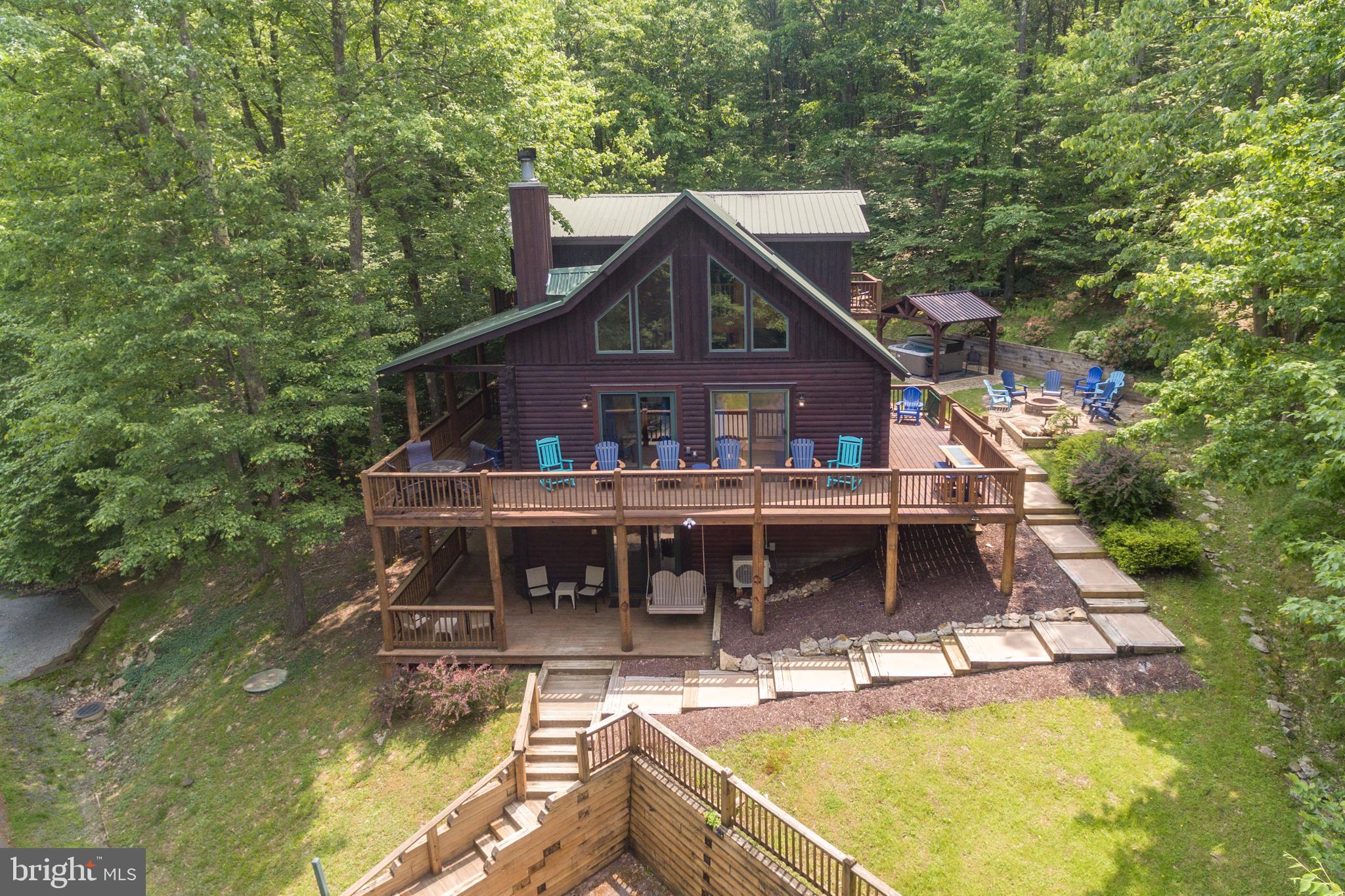 Tucked just off Lakeshore Drive, this log home nails that luxury treehouse feel. Wrapped in fresh stain (09/24) and packed with updates - "Time Is On My Side" is dialed in for comfort. Five bedrooms, three baths, including a main-level primary. Inside, modern meets rustic with a sleek kitchen, new propane fireplace, and fresh paint throughout. The lower level offers a second living area, pool table, new mini-split (2023), and updated flooring (2022). Outside? Abundant outdoor living space! The wraparound deck and lower patio is partially covered, providing sun when it's sunny and shelter when it isn't. The private backyard adjoins community greenspace with built-in fire pit and covered hot tub pavilion. All new TVs and furniture throughout. Whether kicking back inside or soaking up the outdoors, this place was built to be enjoyed any time - any season. With this Deep Creek Lake getaway... time really would be on your side. Call today to book your private tour!