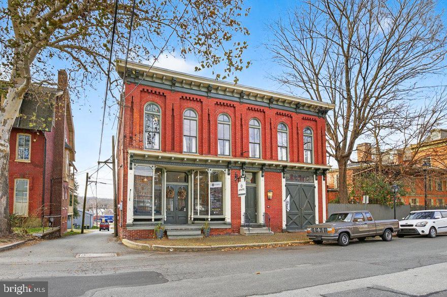 Imagine owning a remarkable piece of history in the heart of a vibrant downtown, surrounded by thriving local businesses. This exceptional property—currently operating as a Oriental Rug Store, event space, and coffee shop—offers a rare opportunity for entrepreneurs, creatives, and visionaries alike.
The striking façade showcases two large cantilevered storefront display windows, intricate wood detailing, and a distinctive brickwork pattern embedded in the sidewalk. Inside, historic charm meets modern comfort with thoughtfully updated features, including beautifully refinished wood floors throughout and custom hand-blown glass light fixtures crafted by a local artisan. The building offers spacious rooms on each level, with a full bathroom on every floor and a full kitchen on the second floor. Adding to its versatility is a second-floor living space above the commercial area—ideal for a live-work lifestyle—complete with a small, fenced-in yard. Whether you envision this property as a private apartment, a coffee shop, antique store, boutique, event venue, creative studio, or a combination of residential and commercial use, the possibilities are truly endless. This unique property seamlessly blends historic character with modern convenience, making it a standout investment. Explore the features, imagine the potential, and make this iconic Lancaster landmark your own. Call today to schedule your private showing. Opportunities like this don’t come often—don’t miss your chance to own a piece of history.