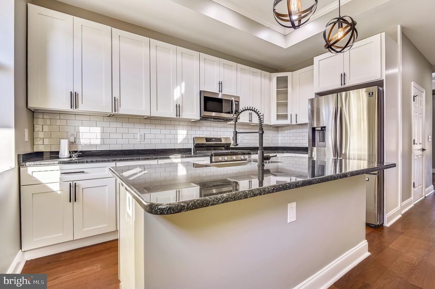 Newly renovated four-story brick home in Reservoir Hill neighborhood to call your own. Enjoy new wood flooring throughout, some historic architecture restored to be enjoyed on a daily basis. The main level is great for entertaining, then take the party outside to the deck and private patio that is fully fenced in. The kitchen has granite countertops with stainless steel appliances and lots of cabinet space. The main level has beautiful, exposed brick in the living room, a gorgeous eat-in kitchen with a separate dining room area. Main level powder room.  Enjoy the Tray ceilings throughout the home. The first upper-level features one bedroom with an en-suite, and two additional bedrooms and a full hall bath with granite countertops. Second floor hall bathroom has beautiful mosaic tiles and granite countertops. On that level, there is a deck off the bedroom in the back. To top it off, laundry room on the first upper level, so no need to trek to the basement. The exquisite top-level primary bedroom is its own oasis, with a massive walk-in closet, palatial bathroom with soaking tub and shower, tile flooring and double vanity, with deck off the bathroom and granite countertops. The basement has open areas with a powder room. Two recently installed HVAC systems for efficiency. Control the temperature from your phone with the Ecobee Thermostat  You can also enjoy and enclosed backyard. Ready for you to move in.