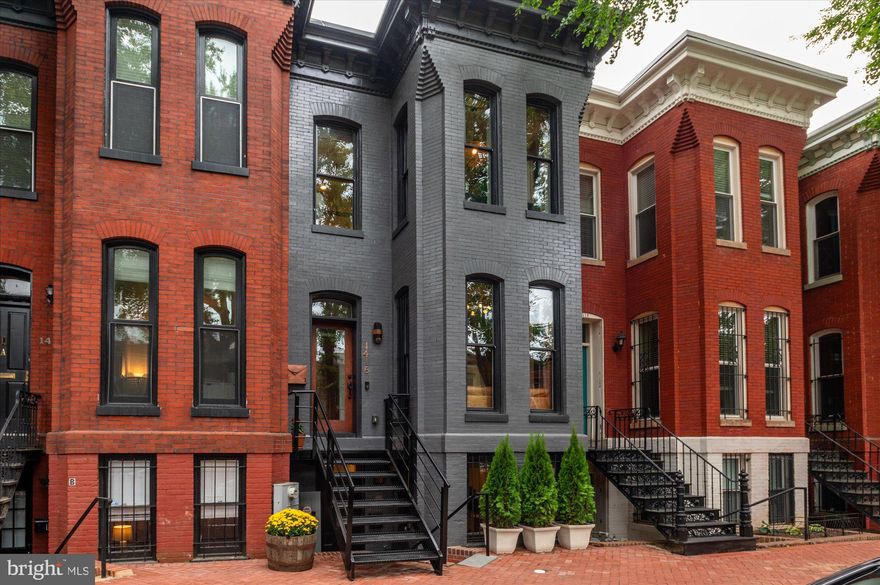 Welcome to this stunning Victorian row home, perfectly blending historic charm with organic modern luxury. This impeccably renovated residence is enviably located on coveted Swann Street in the heart of Logan Circle. Fully remodeled and expanded in 2020 with updates as recent as 2024,  This home has been completely transformed for modern city living and entertaining, the home features breathtaking historic details and bespoke finishes throughout. Dramatic 11-foot exposed beam ceiling, walnut herringbone floors, exposed brick, wood burning fireplace, and large windows for an abundance of light. An open floor plan provides a comfortable living room with a bay window and a wide dining room leading into the custom-designed Jack Rosen kitchen outfitted with Neff cabinetry, Thermadore appliances, a Zephyr beverage center, heated floors, natural quartzite waterfall countertops, and custom live edge walnut shelving. The main level is completed by a coat closet, a storage closet that includes a Pelican water filtration system, and a powder room. The upper floor boasts two impressive bedrooms. The primary suite offers custom built-ins providing an abundance of storage, a large bay window nook, and a spacious custom walk in closet. The primary, en suite bath includes heated floors, a James Martin double vanity, Hans Grohe plumbing fixtures, and a dramatic rain shower cascading down from within the skylight. The secondary bath has heated floors as well and similar luxurious finishes. The upper level is completed by a full-sized washer/dryer. In between the roof and ceiling is all closed cell foam insulation, which keeps the utilities extremely low. The lower level has private front and rear entrances and features a family room, full kitchen, 2 bedrooms, 2 bathrooms, and separate laundry. Other notable features of the home include a rear deck equipped with a natural gas line for grilling, a spiral staircase leading to a large private roof deck offering sweeping city views of the Masonic Temple, the Ginko treetops, and a partial monument view! The property is completed by secure, off-street parking for 2 full-sized cars. No detail has been overlooked, and no expense has been spared in this stunning residence, perfectly nestled on one of the most desirable streets in Washington, DC, and just around the corner from abundant casual and fine dining options, grocers, shopping, and entertainment!!