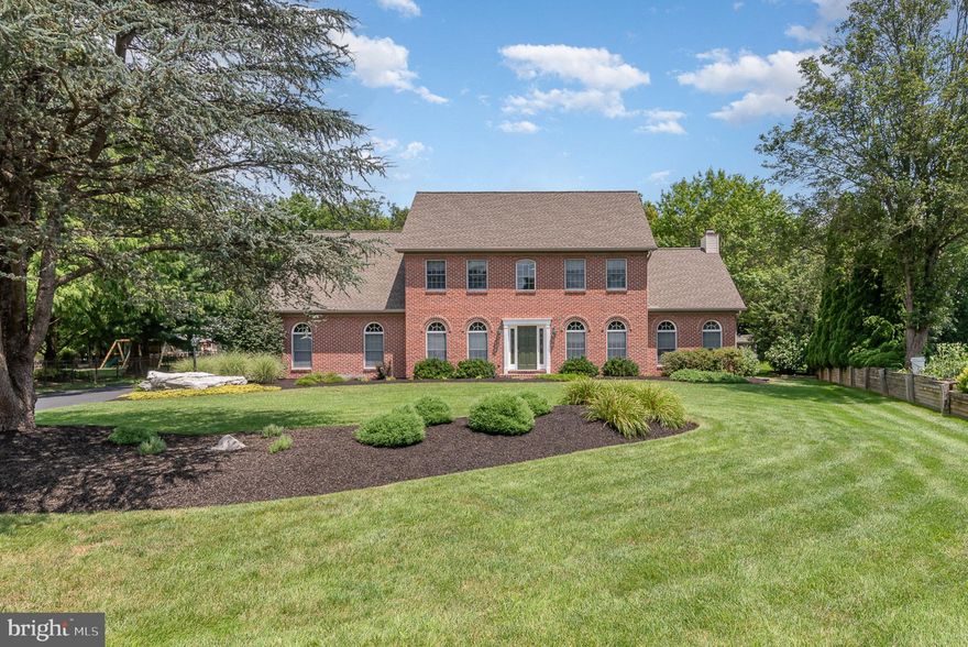 Nestled on over half an acre at the end of a quiet cul-de-sac, this elegant two-story brick-front home in desirable Stonecrest offers both privacy and timeless curb appeal with a side-entry garage and mature landscaping.  Step inside to find 9-foot ceilings throughout the main level, creating a spacious and airy feel that complements the home’s classic design.  A welcoming center hall foyer with rich oak hardwood flooring sets the tone as you enter.  Just off the foyer, a formal living room—ideal as a sitting area or home office—features classic crown molding and striking floor-to-ceiling windows, offering both elegance and versatility.  The heart of the home is the beautifully updated kitchen featuring custom maple cabinetry, quartz countertops, a tile backsplash, a breakfast bar, and a spacious eat-in area—ideal for daily living and entertaining.  The formal dining room is generously sized and adorned with crown molding, chair rail detailing, and stunning floor-to-ceiling windows that flood the space with natural light.  Just off the kitchen, the sunken family room boasts a vaulted ceiling and a charming brick wood-burning  w/gas insert fireplace, creating a cozy and inviting retreat. Step out to the expansive 475 sq. ft. screened-in porch, perfect for enjoying the peaceful, private backyard year-round.  Upstairs, you'll find three well-sized bedrooms and an updated hall bath, along with a spacious primary suite featuring a walk-in closet, renovated en-suite bath with whirlpool tub, dual vanity, and a conveniently located laundry room.  The finished lower level offers additional living space—ideal for a media room, home gym, or playroom.  Lovingly maintained by its original owners, this home is a rare opportunity in a sought-after neighborhood.