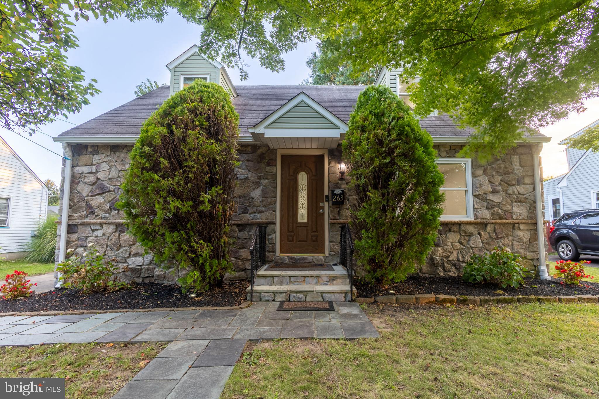 Welcome to this charming Cape Cod home filled with updates and thoughtful details. A New water heater, New heating and A/C, and Newer recessed lighting throughout (except in the basement) provide peace of mind. Mostly Pella windows brighten the home, while the freshly painted first and second floors create a move-in ready feel. The first floor showcases Refinished Hardwood flooring, a Living Room with an electric fireplace that flows seamlessly into the Dining Room, and the convenience of a First-Floor Bedroom—perfect for one-level living, a guest room, or home office. A beautifully Updated Full Bathroom enhances this level with modern touches. The Kitchen features Newer appliances—including a refrigerator, electric stove/oven, and microwave—plus Freshly Repainted Cabinets and a New garbage disposal. Sliding doors open to a delightful backyard patio with a pergola draped in grapevines, ideal for outdoor dining and relaxation. The kitchen furniture will also remain with the home. Upstairs, you’ll find two additional bedrooms, both with hardwood flooring, offering comfortable space. The heated and cooled basement provides added versatility, complete with two Pella windows, a Half Bathroom, and a dedicated movie room with a projector and speakers. Outdoors, enjoy a pear tree in the front yard, a Newer fence along two sides of the backyard, and a shed for additional storage. The location is a true highlight—close to Grand View Elementary and Morrisville Middle/Senior High School, with convenient access to the US 1 Toll Bridge to New Jersey, two additional nearby bridges, and Bridge Street Golf at Snipes Farm. Some photos are virtually staged.