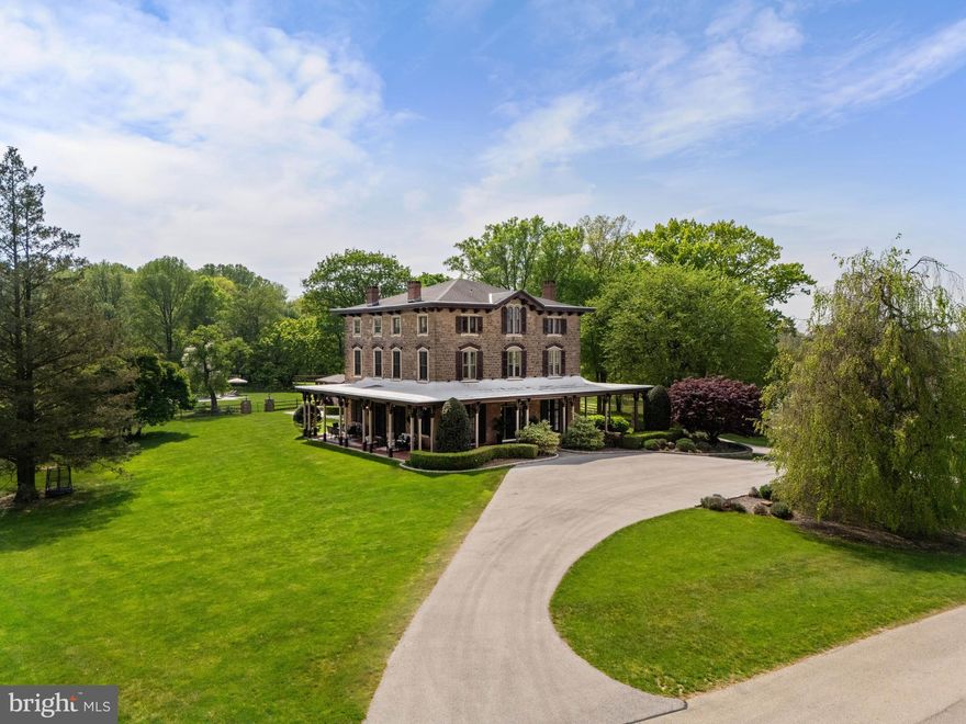 Immerse yourself in historical elegance and luxury at this 8,000+ square foot masterpiece, originally part of the esteemed Armentrout Estate. Nestled within 106 acres of meticulously preserved woodlands and scenic trails, this 8 bedroom, 5 full and 2 half bath Italianate residence underwent a comprehensive restoration in 2009 by the current owners and renowned architect R. A. Hoffman, and was restored with impeccable attention to detail. The estate boasts an array of original features that exude grandeur and craftsmanship, including ornate moldings, multiple marble fireplaces, hand-carved woodwork, and exquisite millwork. An impressive wrap-around porch provides relaxing spaces in which to enjoy the views, punctuated by birdsong. The grandeur continues inside, where the original double front doors open into a stately center hall, flanked by a grand yet comfortable space designed for both entertaining and refined living. Spectacular floor-to-ceiling Jefferson windows bathe the interiors in natural light, enhancing the breathtaking vistas of the estate. To the left, the formal living room with fireplace seamlessly connects through pocket doors to the elegant dining room, adorned with pretty corner built-ins and access to the large wrap-around porch. The expansive gourmet kitchen is a culinary enthusiast's dream, featuring bespoke cabinetry, large marble island, professional-grade 6-burner Wolf stove with double ovens, Sub-Zero refrigerator, and a well-appointed butler’s pantry that includes a rear staircase, powder room, and a versatile mudroom/family entrance. The residence also hosts a delightful wet bar area set against an exposed stone wall, offering direct access to the outdoors. The upper floors are equally impressive, with the primary suite showcasing another marble fireplace and oversized windows that flood the space with light. The luxurious white marble bathroom is complete with a fireplace, soaking tub, walk-in shower, double vanity, and a custom-designed walk-in closet with extensive shelving and storage solutions. Additional bedroom suites and a laundry room with ample storage complete the second floor. Four more bedrooms, a family room with vaulted ceilings, exposed beams and stone walls, and a sunlit office overlooking the grounds and pool, finish off the third floor. The third floor houses more bedrooms, additional storage areas, and a cedar closet. Descend to the basement to discover a spectacular Italian villa-inspired wine cellar and tasting rooms, featuring slate floors, brick arches, and stone walls—perfect for hosting wine tastings and intimate dinner parties. A climate-controlled wine storage room ensures the preservation of valuable collections, and a spacious room with a wet bar, dishwasher, and beverage fridge offers ample space for hosting. The estate's grounds are a sanctuary, featuring multiple gardens, mature trees, an historic icehouse, picturesque stone walls, sitting areas, and a tranquil pool with bluestone patio and pool house. Surrounded by the Camp Woods and Armentrout Preserves, the estate offers easy access to major roads, vibrant shopping and dining, Wings Field, and the train station, ensuring a convenient commute to Center City Philadelphia or New York City. This property is not just a home, but a legacy of luxury and history ready to be cherished by its new stewards.