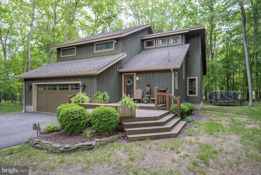 Lake Access with a Dock Slip located in the highly desirable Blakeslee community. This 3-bedroom, 2.5-bath mountain retreat offers the perfect mix of comfort, style, and Deep Creek Lake living.  An open, inviting layout give the home a refreshed, updated feel, while the sun-filled four-season room quickly becomes the standout space of the home. A stunning pass-through stone fireplace anchors the main living area, complemented by stainless appliances, central A/C, and warm mountain character throughout. Outside, the spacious back deck and brand-new hot tub create the perfect setting for relaxing or entertaining. The oversized garage has been converted into a rec room complete with new game tables, adding even more space to gather and unwind. Situated on a private, wooded acre with a private dock slip nearby, this property also includes access to Blakeslee amenities including an indoor pool, tennis courts, walking trails, and more. Whether you’re searching for a full-time residence, vacation home, or investment property, this home checks all the boxes. Call today for details!
