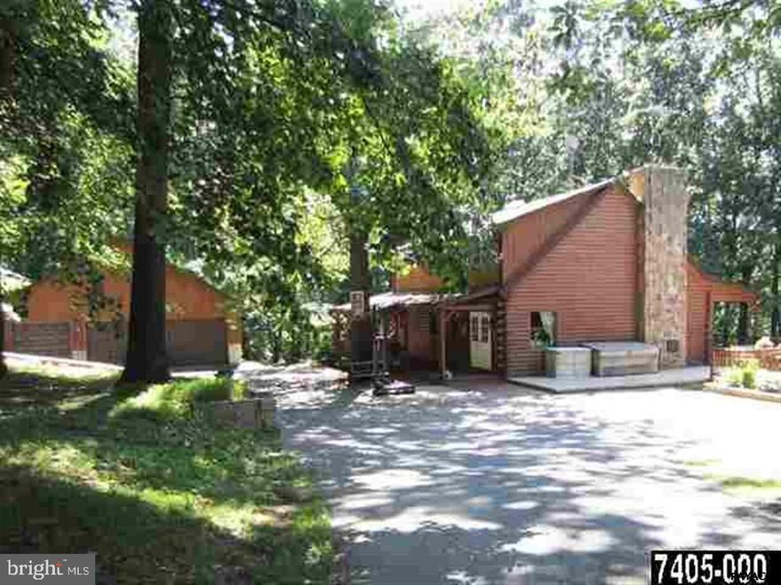 Natural seclusion with this great Log Cabin on 5+ wooded acres and C-front/rear porches. Soaring cathedral ceiling in LR/GrtRm feats stone wall w/coal stove for aux heat. Kit w/brkfst bar. 5BR incls MBRsuite/3FB/2HB-thruout home. Cozy loft ovrlooks 1st fl. Lwr lvl offers in-law qtrs w/walkout to patio leading to an inviting in-ground pool. 3-car detached garage.