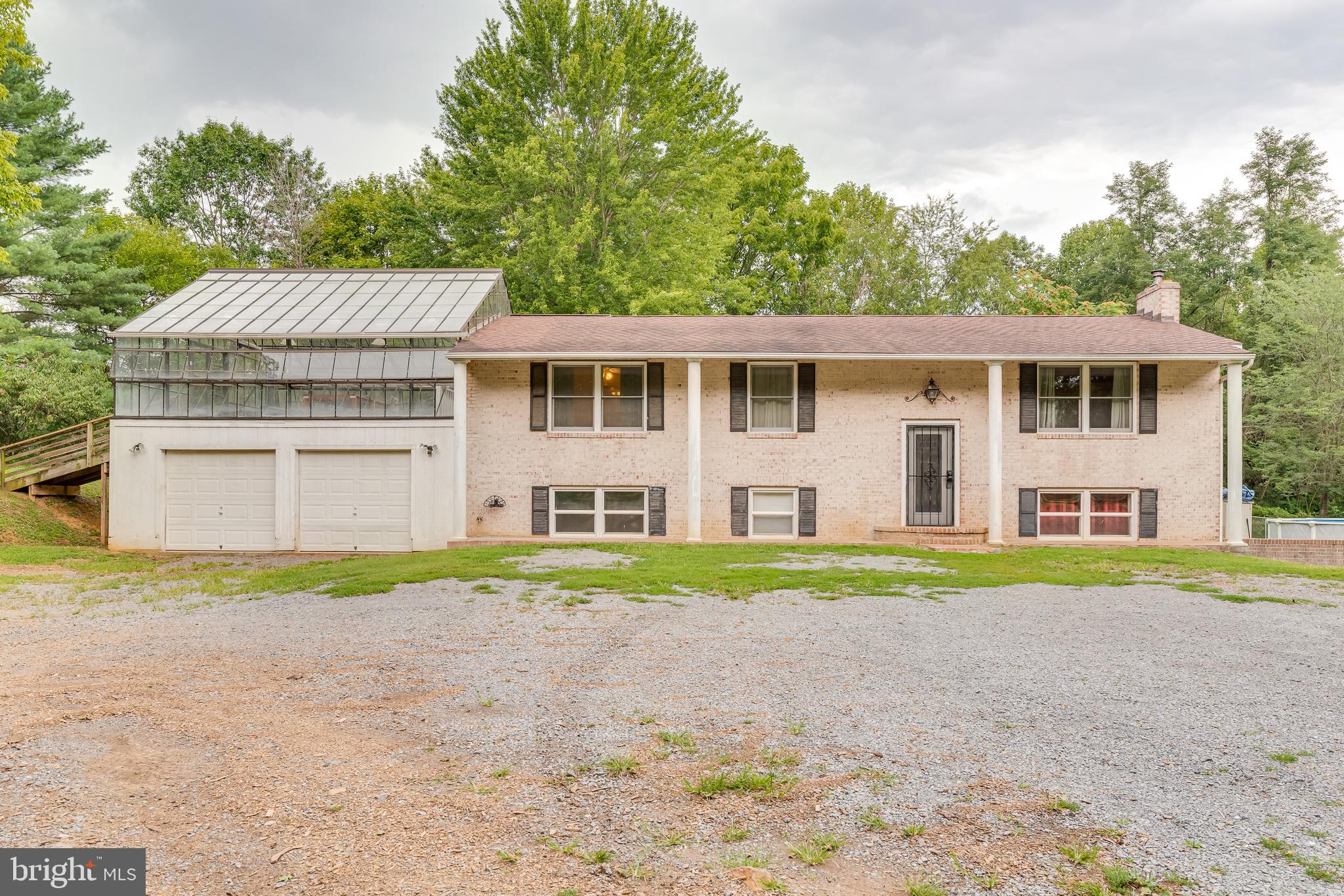 This unique property sits on just over 2 acres of lush UNRESTRICTED land. This split foyer features a large living room, dining room and kitchen with ceramic tile on the main level. The 2 main floor bedrooms are generously sized and include hardwood floors. The full bathroom is stunning with copper ceiling and walk-in shower with multiple showerheads and 2 seats. The lower level of the home features a large family room with wood burning fireplace and pellet stove to keep you toasty on cold nights. The lower level includes 2 large bedrooms, a full bath with laundry and hobby room. The hobby room includes base cabinets and a large farm sink. It could easily be converted into a 2nd kitchen. This would make the lower level a perfect in-law suite! The rear of the home features a deck running the full length of the home and a large above ground pool. Great space to enjoy the summer! This home is really unique featuring a 24x24 greenhouse. Use is to grow or repurpose as a stunning sunroom. Below this is the 2 car garage. This home has so many unique accents it's sure to fast! Don't wait - Call for your showing today!!