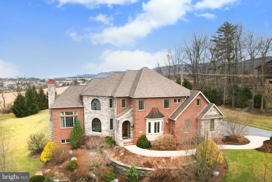 This extraordinary custom estate near campus has an impressive 5 bedrooms, 4.5 baths, 5,746 sqft on 1.51 acres with million dollar views! 235 Meadowsweet sits on a premier location in the desirable Stearns Crossing Neighborhood. This magnificent custom residence, thoughtfully designed and constructed in 2010 by respected builder Dick Rider, delivers an extraordinary lifestyle with over 4,670 square feet of meticulously designed above-ground living space, plus an additional 1,076 square feet in the finished walk-out basement. Unlike cookie-cutter properties, this unique home showcases exquisite craftsmanship and distinctive character throughout its spacious floor plan.
Ideally situated close to Campus, Beaver Stadium, Downtown State College, and Spring Creek Park, this property offers the perfect blend of convenience and privacy. The generous 1.51-acre lot provides beautiful views for miles, and ample space for outdoor enjoyment and future enhancements, including room for a pool. 
The heart of the home is the stunning gourmet kitchen, designed for both serious culinary exploration and elegant entertaining. Premium natural gas cooktop, professional-grade appliances, and custom cabinetry create a chef's paradise. The thoughtful layout flows seamlessly into dining and living areas, making it ideal for both intimate family meals and grand gatherings.
The attention is in the details. This extraordinary residence features a handcrafted wooden front door making a striking first impression, premium Anderson 400 casement windows throughout, and three elegant fireplaces creating warmth and ambiance throughout the home. The environmentally conscious geothermal heating and cooling system is complemented by dual 50-gallon water heaters ensuring abundant hot water for the entire household. Natural gas amenities extend beyond the kitchen to include three fireplaces and an outdoor grill for al fresco entertaining. The entire home is fully wired for sound and comprehensive security, offering both convenience and peace of mind. Second-story bathrooms feature luxurious heated floors, while rich hardwood flooring flows throughout the main living areas. The second-floor owner's suite boasts a custom tile shower, and large walk-in closet. A dedicated first-floor bedroom with a private bath currently serves as a sophisticated home office. Pet lovers will appreciate the thoughtful inclusion of a custom dog shower, demonstrating the home's attention to every family member's needs.
The thoughtful floor plan offers a perfect balance, with 2,363 square feet on the first floor and 2,307 square feet on the second floor there are ample private spaces for family members and guests alike. The walk-out basement features its own full kitchen, making it ideal for entertaining or accommodating extended stays with complete privacy.
Beyond the impressive living areas, this property includes an oversized three-car garage spanning 973 square feet and 1,354 square feet of unfinished basement with a convenient back stairway direct from the garage—perfect for storage, workshop space, or future customization to suit your needs.

This residence stands as a testament to architectural excellence and refined living, where every detail has been carefully considered to create spaces that are both grand in scale and intimate in comfort. The fluid layout transitions seamlessly between formal entertaining areas and casual living spaces, making this home perfect for both sophisticated entertaining and comfortable family life.
Video Tour is available by request.