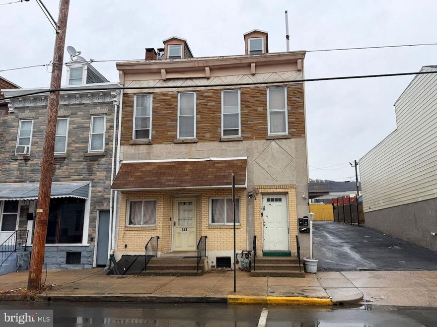 Attached brick front property located in Reading. The property contains approximately 3,098 square feet of living area on a small city lot. The home was built around 1887 and includes multiple levels of living space with several kitchens and bathrooms that appear to have been added over time. Interior finishes are dated, and the property shows signs of deferred maintenance. Rooms are generally functional but will require updating and repairs. Existing kitchens and baths are basic and worn, and some areas were previously configured for multiple occupants. The property has a full basement and rear yard area with alley access. Public records identify the property as a single-family dwelling; however, it was previously marketed as a multi-unit property. Any continued or future multi-unit use would require verification and approval through the City of Reading zoning and code process. This property should be viewed as a renovation project for a purchaser willing to complete updates and improvements. Potential exists for reconfiguration or conversion to a multi-unit property subject to municipal approval. Property is being offered in as-is condition.  Any municipal inspections are an obligation, and at the expense of the purchaser.