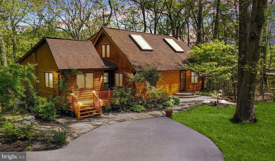 This stunning log home on 2.48 scenic acres offers the perfect blend of rustic elegance and thoughtful upgrades. Surrounded by lush landscaping, the property provides treetop views and a glimpse of the water during the winter months. The impressive two-story living room showcases a dramatic wood-burning fireplace and flows effortlessly into the dining area and the gourmet kitchen, which features granite countertops, a breakfast bar, ample cabinet space, and all major appliances.

Three generously sized bedrooms are located on the main level, each with gleaming hardwood floors. The primary suite includes a ceiling fan, walk-in closet, a spa-like bathroom with a soaking tub and separate shower, and private access to the deck.

Upstairs, a sunlit loft with oversized skylights offers flexible space for a home office, family room, or den and includes a full bathroom. The finished basement adds even more living space, with a spacious recreation room featuring wall-to-wall carpeting and recessed lighting, a fourth bedroom, a laundry area, and plenty of storage.

Outdoor living is just as inviting, with a large rear deck that backs to wooded privacy and a welcoming front paver walkway and deck. The driveway provides ample parking, and the home is just a short walk from community beach access.

Ideally located near major highways and downtown Annapolis, this home offers tranquil surroundings with convenient access to shopping, dining, and everyday necessities.