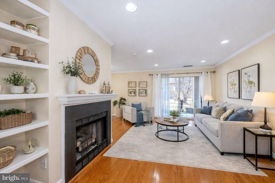 This beautiful move-in ready 1 bedroom, 1 bath condo offers a bright open floor plan with gleaming hardwood floors, crown moldings, custom built-ins, gas fireplace, upgraded recessed lighting, and large windows that fill the space with natural light. The updated kitchen features white cabinetry, granite countertops, tile backsplashes, and stainless-steel appliances. The unit also includes a full-size stackable washer and dryer for added convenience. The spacious bedroom boasts plush carpeting, 3 closets with mirrored doors and custom organizer and access to the well-appointed full bath with a granite topped vanity and tub/shower with spa toned tile.  Enjoy lush and peaceful views of the pond and fountain from your private rear patio. Ideally located with easy access to Dulles Airport and the Ashburn Metro Station. The Ashburn Village Sports Pavilion is right next door, offering incredible amenities including indoor and outdoor pools, tennis courts (domed in winter), racquetball, indoor basketball courts, and a full fitness center. Residents can also enjoy scenic walking and biking trails that wind around the lakes and throughout the community. One reserved parking space is included directly in front of the building, with plenty of additional guest parking available. It’s the perfect home in a stellar location! The first four photos contain virtual staging.