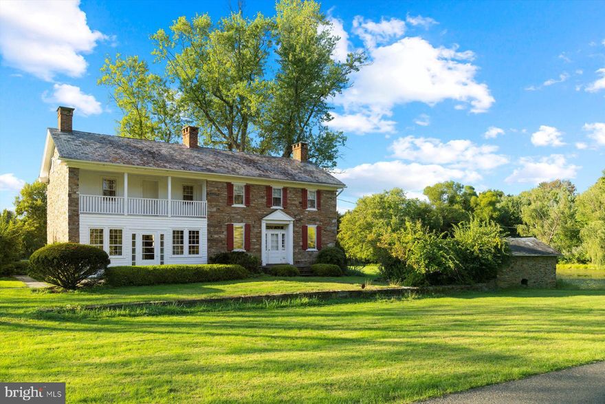 Almost 40 years ago, a couple from New York City discovered Bucks County and its stone farmhouses and barns. They wanted a weekend property, something that provided complete serenity away from the city. What they found is c. 1759 Springhouse Farm, 16+ acres along a hidden country road above Carversville. Over the years, they undertook many renovations and updates, smoothing its rough edges and turning it into a gem of a country property. Stone was repointed, reclaimed pumpkin pine floors were installed and existing floors refinished; stairs and custom storage were added; attic spaces were finished and floor plans were changed to create a sensible bedroom and bath arrangement. When more living space was needed, they moved on to the barn and added a guest suite with a great room, kitchen, bedroom and two full baths. Now, Springhouse Farm seeks its next stewards. From its Living Quarters kitchen cabinetry to its two fireplaces for winter enjoyment to its top-notch mechanicals, it’s a move-in ready residence with lovely views, especially from the screened rear porch and kitchen patio. The second-story veranda is accessible from the main suite and a guest bedroom. There is perhaps no better spot in Plumstead to enjoy a morning coffee or a little stargazing at night. The main bedroom includes a full bath and two closets. With a pond, large springhouse, in-ground pool with lap lane and acres of level pasture, Springhouse Farm offers all of the ingredients one needs for a bucolic hobby farm or estate property. Also note that the total acreage with the house and barn on separate parcels means it could become three smaller properties. Adjacent to the barn is a large meetinghouse-style storage shed and an outbuilding that could be perfect for any number of uses, from an artist who needs a large studio to a car collector to a fitness buff who wants a gym as large as a commercial space. Located in between New Hope and Doylestown, Springhouse Farm is a celebration of Quaker simplicity and natural beauty that makes Bucks County a much-loved retreat to this day.