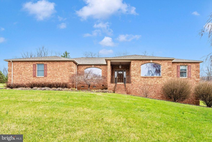 Beautiful custom built, all brick, spacious home in a country setting with a partial wrap around porch on 3.5 private acres that overlook mountain views. This home has timeless features designed for beauty and comfort. There are many upgrades such as crown molding, chair railing, marble floors in the bathrooms, hardwood floors in the formal Dining Room, Hallways and Entrance, tinted Anderson windows and Pella doors throughout, and custom hickory cabinets in the kitchen and bathrooms. The front entrance offers a nice porch with plenty of room to enjoy the sunset.The kitchen has an eat-in area with a french door that opens onto the back porch, granite countertops, double oven, downdraft cooktop on the center island, extra large pantry, and microwave.  The extra spacious Family Room has cathedral ceilings and an all brick, gas fireplace. The guest bath in the hall offers plenty of privacy. The oversized formal Dining Room can accomodate large gatherings and is ideal for hosting parties and family holidays. The Formal Living Room offers a peaceful place to spend quality time with guests. or simply take time to unwind. The Luxurious primary bedroom leads to your own private oasis with a large soaking tub and separate shower.  The huge walk-in closet has plenty of room plus some! The Guest bedroom has its own private bath with a shower/tub combo and walk-in closet as well. Enjoy the security and comfort of a whole house generator with battery back-up. Plenty of large closets throughout the home.  Lots of space for tools, storage, etc. in the extra large 2-car garage. For convenience, the mud/wash room is off of the garage. The walk-out basement is unfinished and has a full bath rough-in. There is potential for at least 2 bedrooms with windows with a large bathroom and plenty of room for entertaining. This home is carefully maintained; has beautiful mature trees and manicured lawn, a new roof (Nov 2025), recent HVAC w/humidifier, H/W heater, and more. Close proximity to National, State and local parks, wineries, farm markets, hiking trails, river activities and so much History. Close to Frederick, Hagerstown and Harpers Ferry.  Don't wait - this could be yours!